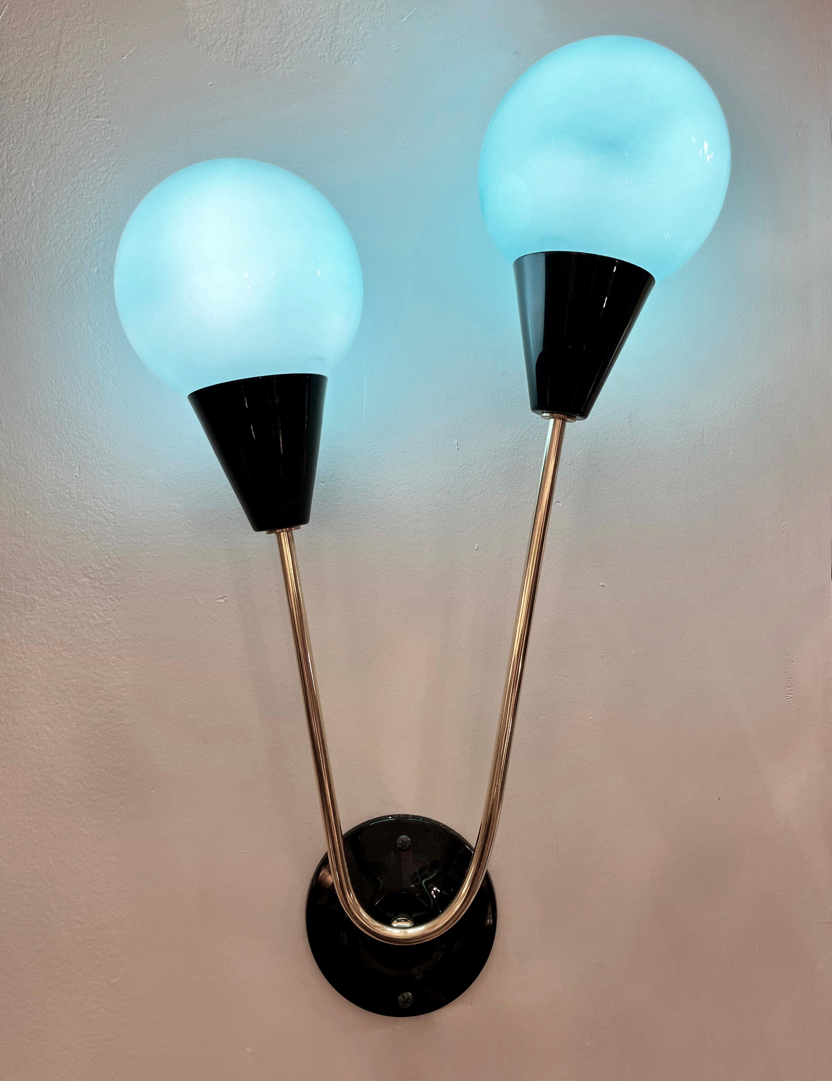 Contemporary Mid-Century Modern wall lights with Stilnovo inspiration, entirely handcrafted in Italy, with aquamarine ocean blue glass shades that are overlaid in white glass to produce plenty of glowing light when lit. The handmade round backplate