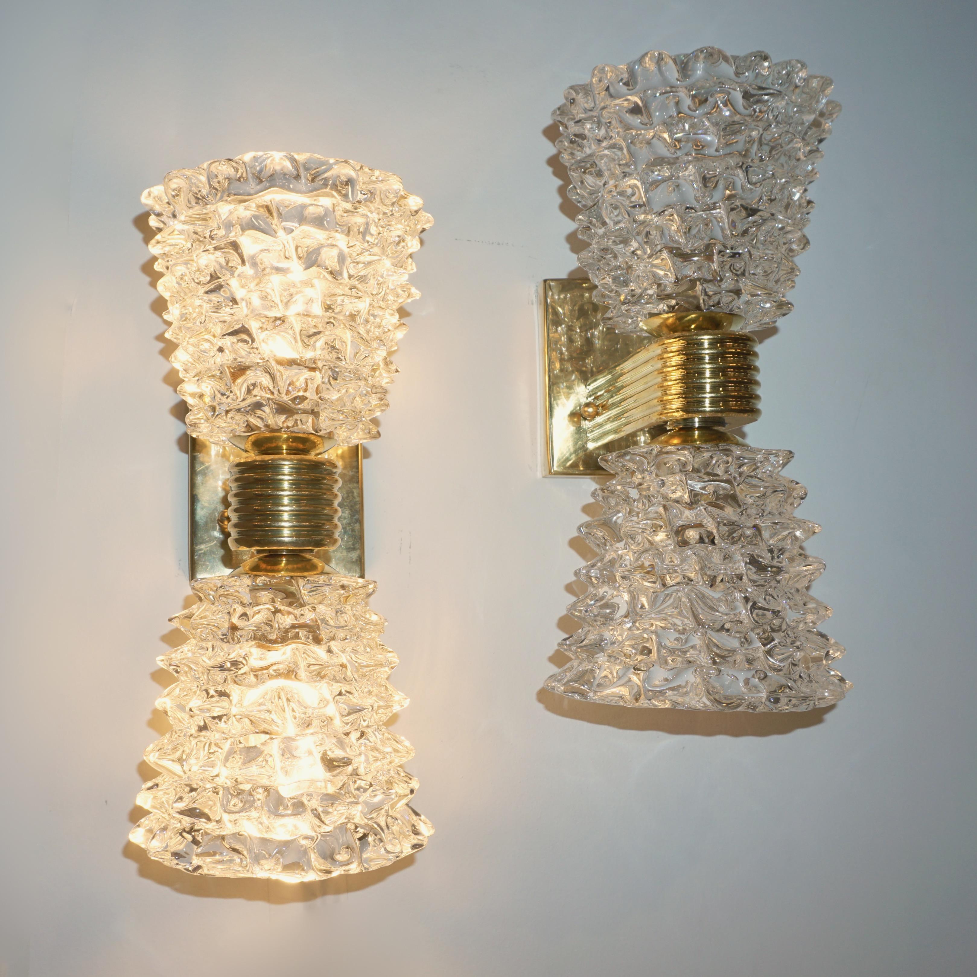 Organic sculpture pair of modern crystal clear Murano glass wall lights in the Art Deco style of Barovier Toso, entirely handcrafted in Italy, with double cone shape shades providing upward and downward light source, made using the rostrato