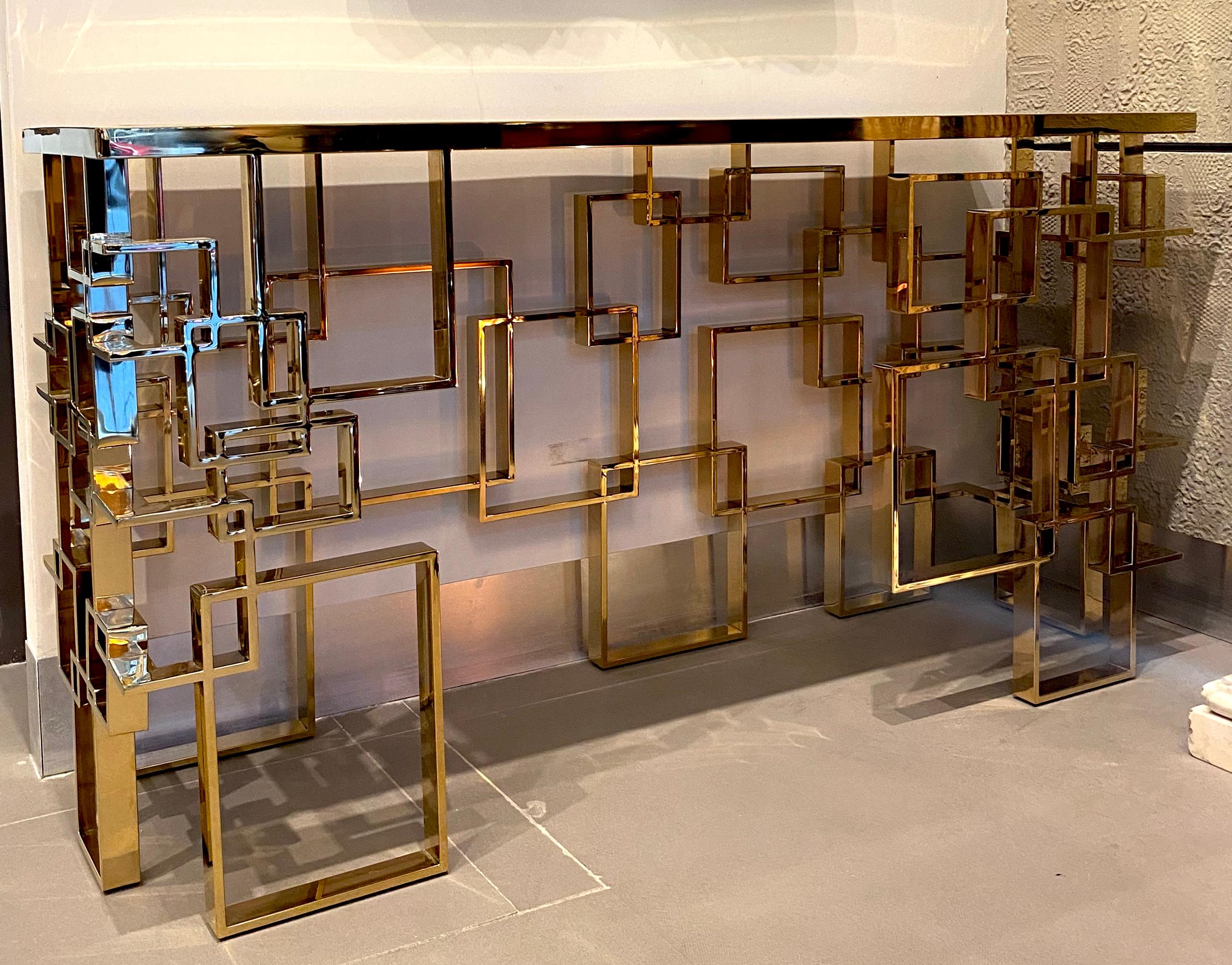 Fabulous modern brass sculpture console table or center table with a Mondrian motive glass top. 
Handmade by a master artisan.
The glass top color we can customize on request.
Available also a pair.