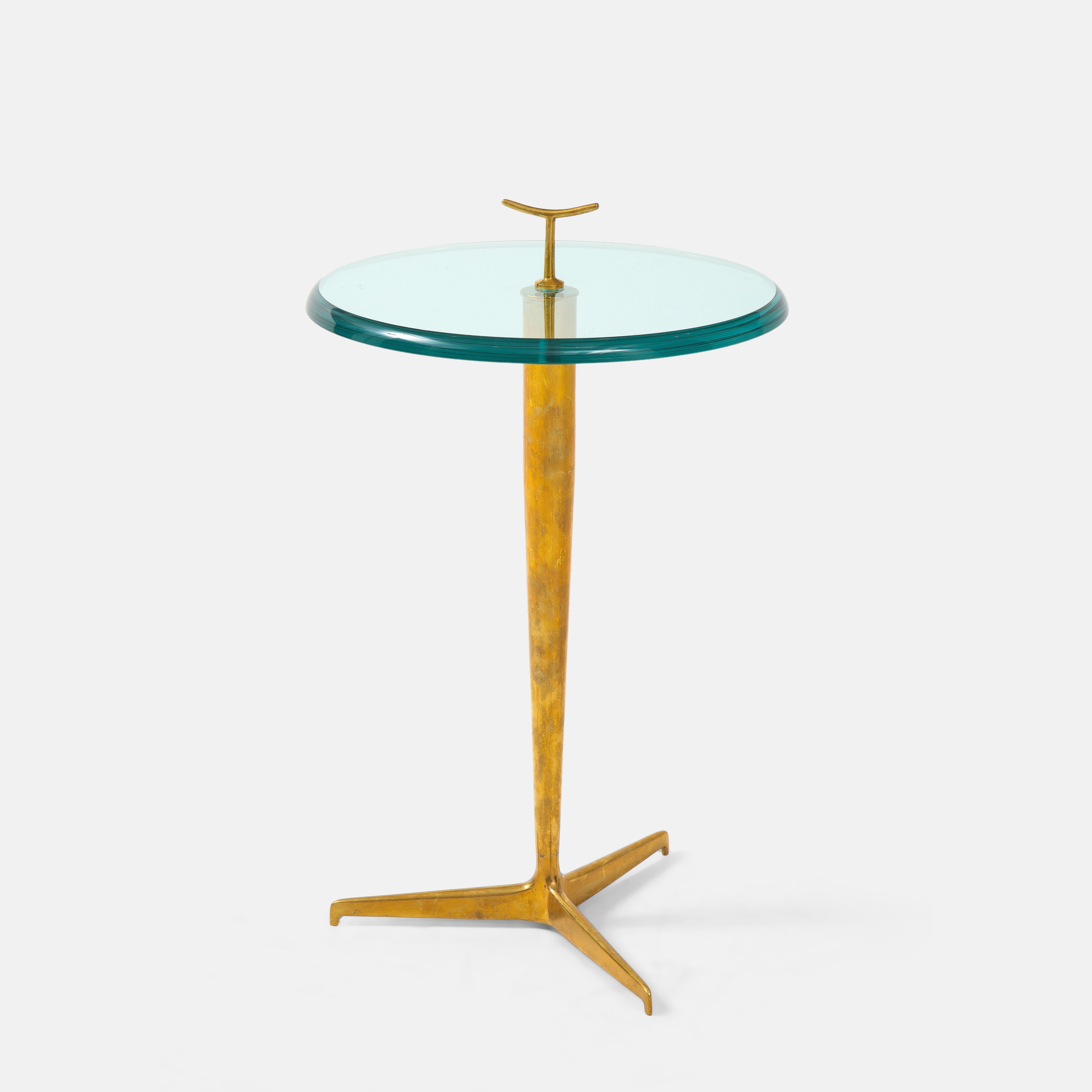 Side, occasional or drinks table in thick beveled glass with small brass handle detail on patinated brass tripod base, Italy, 2023. This chic modern side table is beautifully constructed with thick lens cut polished glass and richly patinated brass