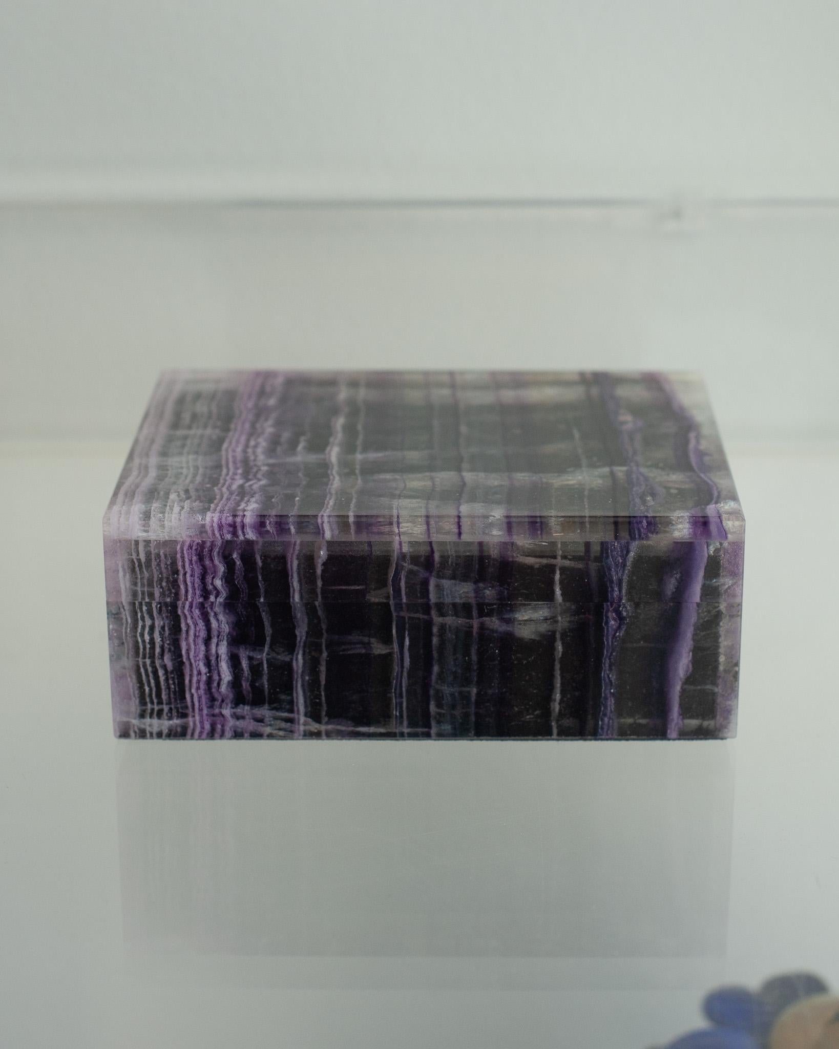 Invite healing energy into your home with an exquisite small purple fluorite box. This box is beautifully made with a hinged lid and expert construction. Lined in black velvet with black marble trims. Finished to a high polish to show off the