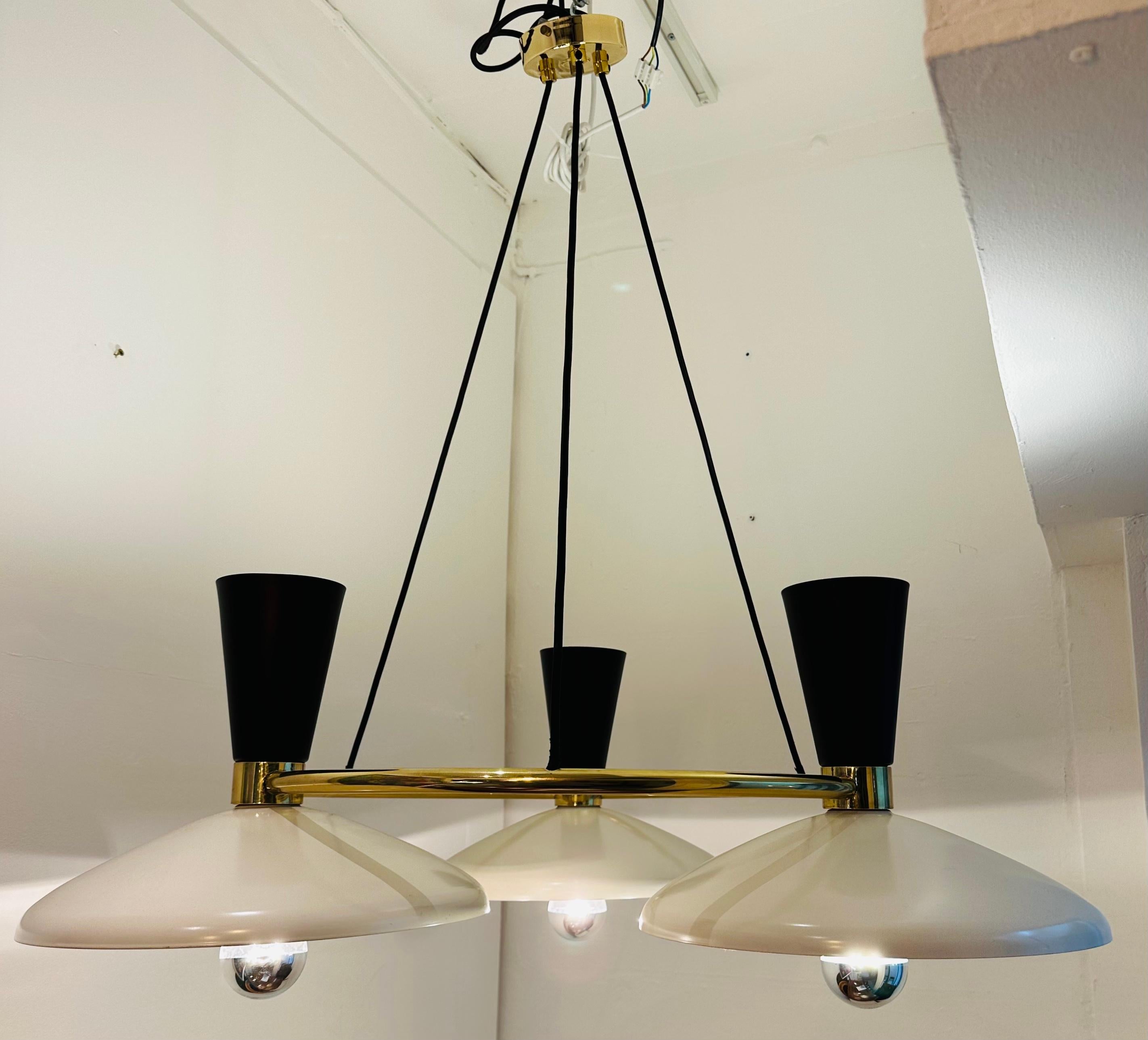 A contemporary 1950s Stilnovo Italian style 3-shade chandelier manufactured in the United Kingdom.  The powder-coated off-white lower wider down-lit shades are complimented with a powder-coated uplighting black shade above.  The shades are supported