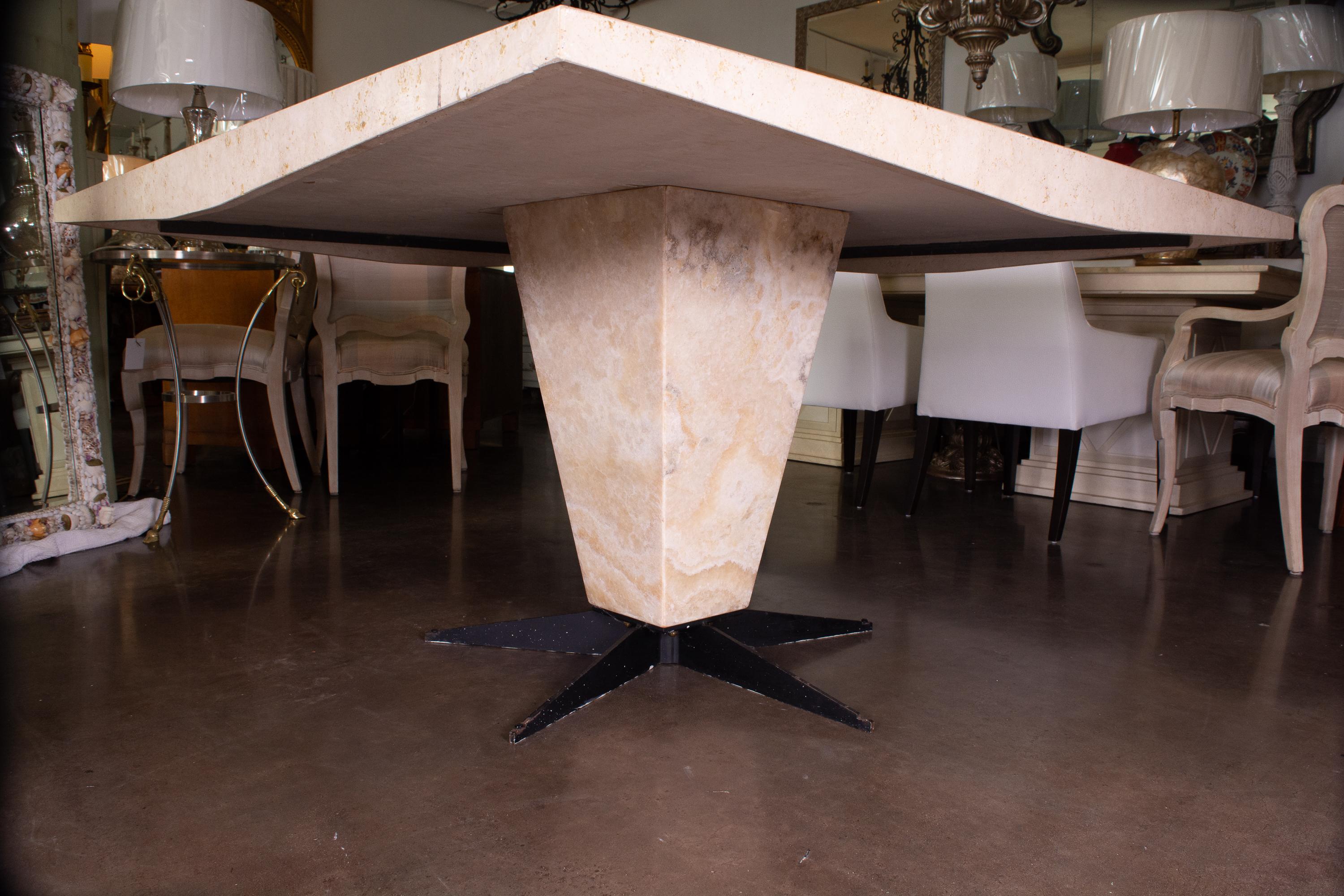 This is a stunning Italian square travertine table. The top has a straight edge and is supported by a large square tapering pedestal situated on a star-form metal base, mid-20th century.