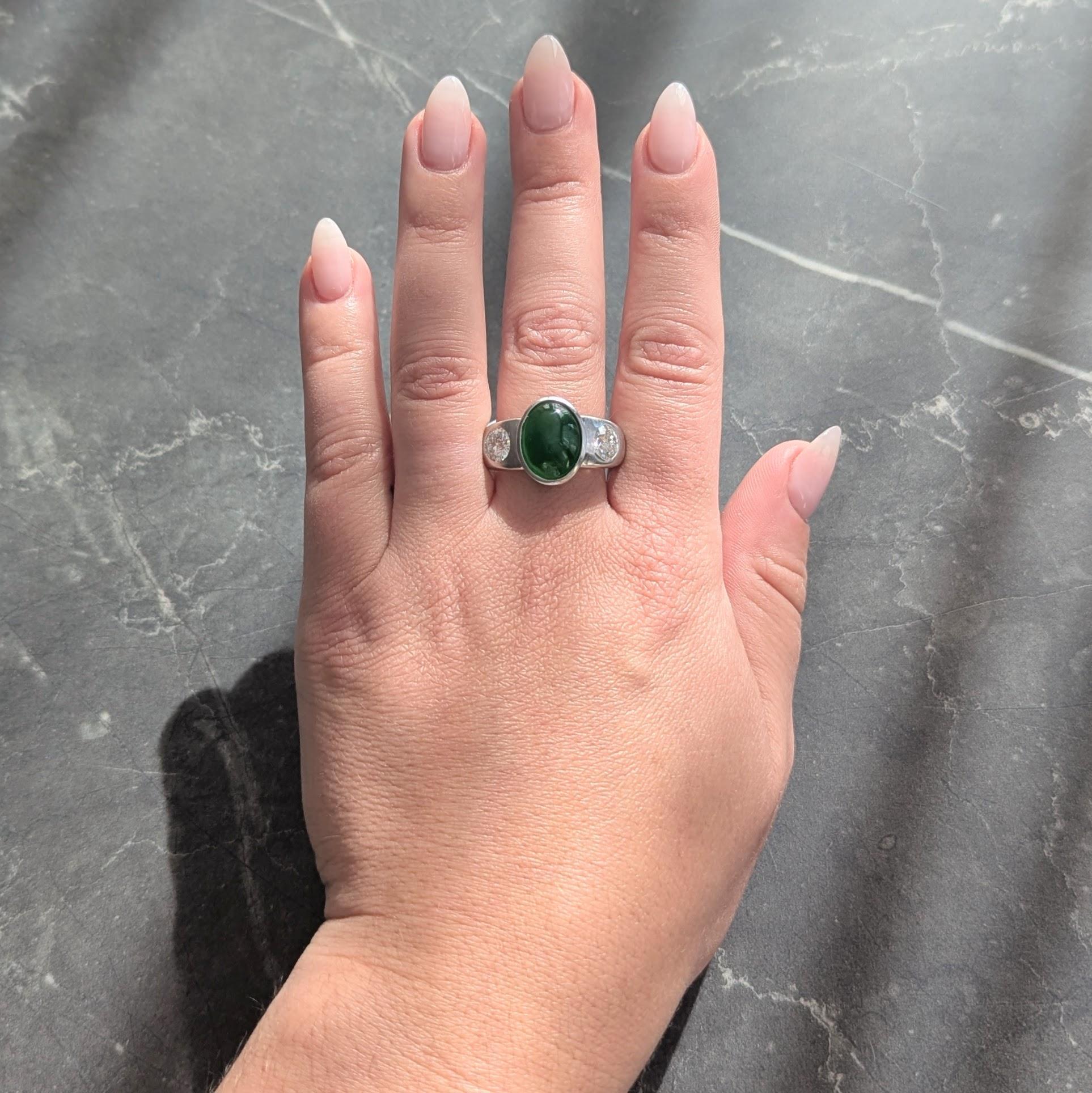 Centro de un cabujón de jade de forma ovalada que mide 13,0 x 10,0 mm - verde vibrante medio transparente
Bisel engastado en platino y flanqueado por diamantes de talla europea antigua engastados a ras
Peso total aproximado de 1,70 quilates - Color