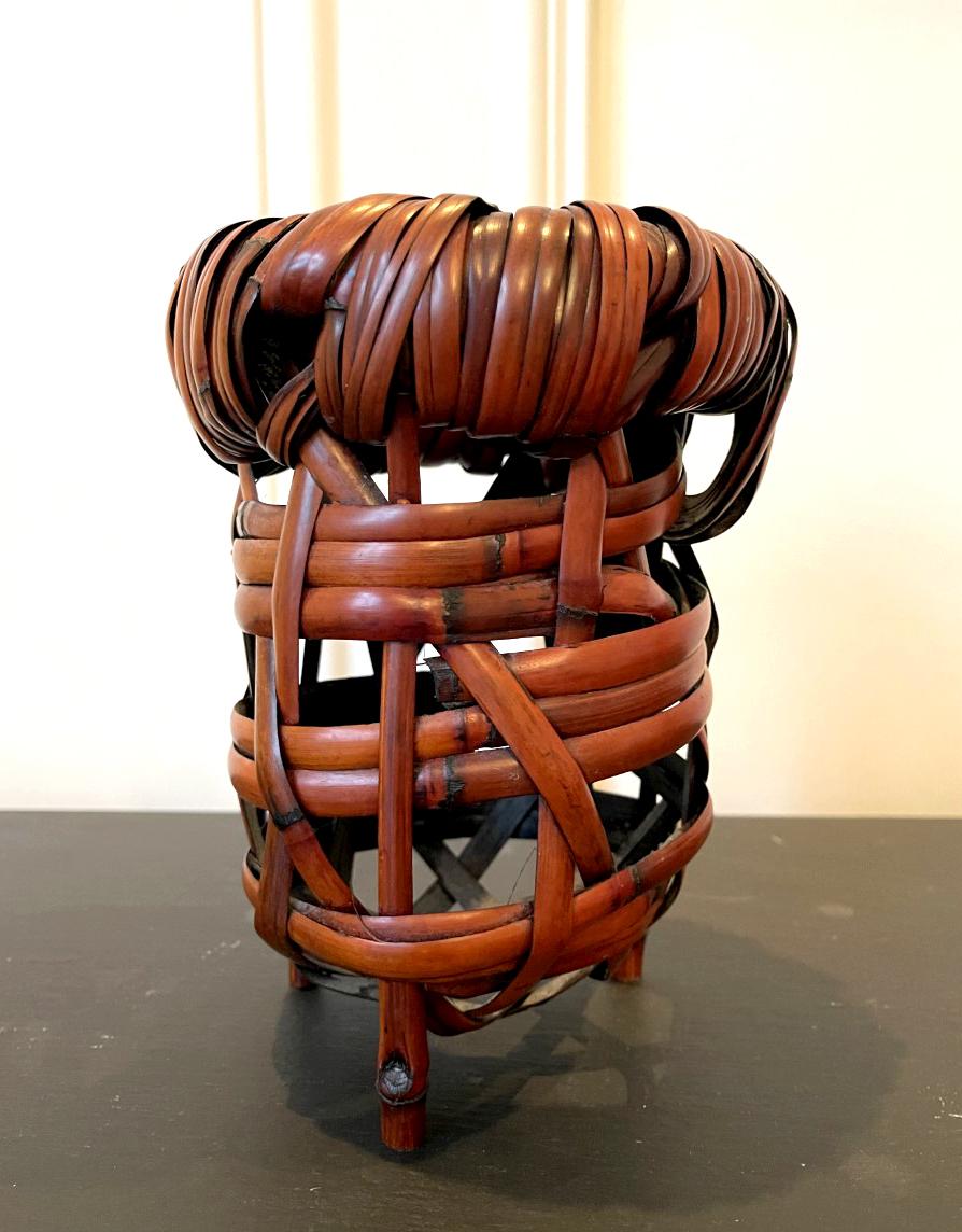 A woven bamboo sculpture in a basket (ikebana) form named 
