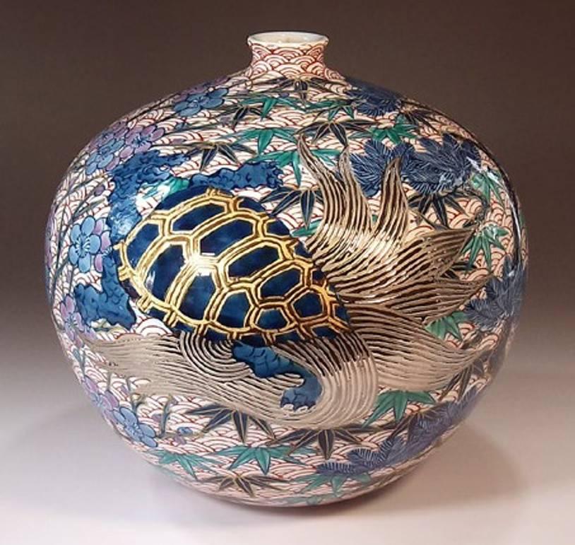 Intriguing Japanese contemporary decorative porcelain vase, gilded and hand-painted in blue and red on a beautifully shaped ovoid pure white porcelain body, a signed piece by highly acclaimed master porcelain artist of the historic Imari-Arita