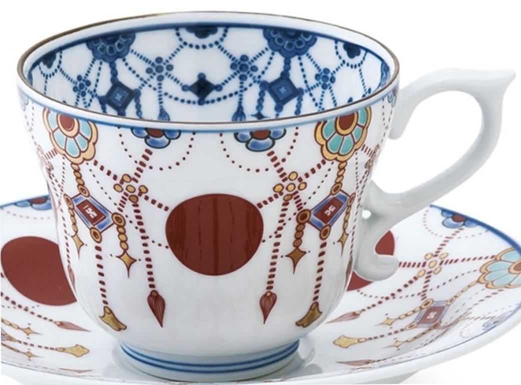 Unique contemporary Imari style intricately gilded and hand painted porcelain cup and saucer. This attractive piece with its stunning pattern in deep red and blue and generous application of gold manifests the same pattern inside the cup in
