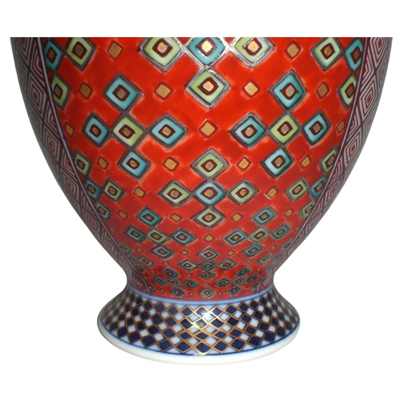 Exquisite zeitgenössische dekorative japanische Porzellanvase in einer außergewöhnlichen Form mit zwei faszinierenden und detaillierten geometrischen Fortschrittsmustern, die extrem aufwändig von Hand in Rot und Blau gemalt wurden. Ein signiertes