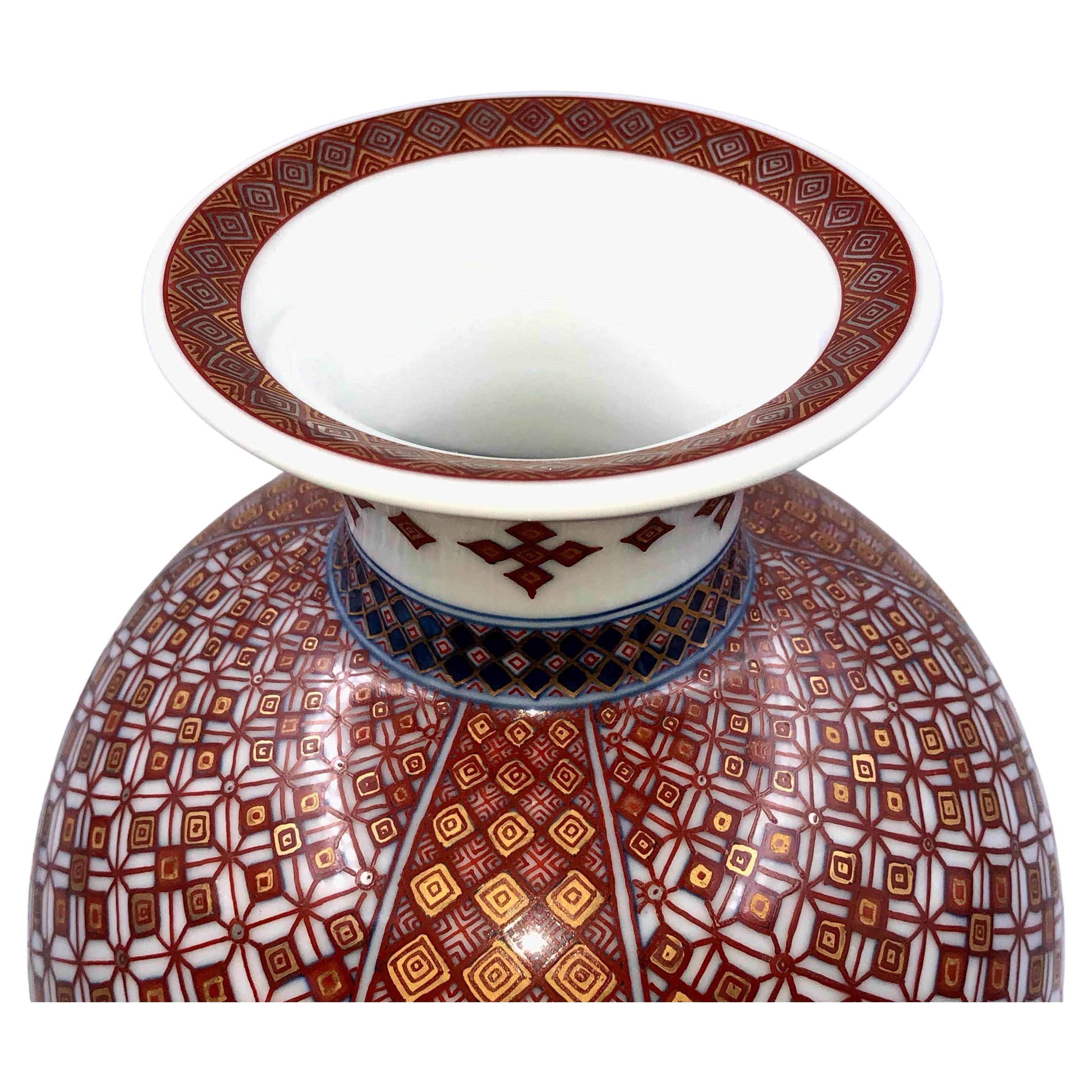 Exquisite Japanese museum quality contemporary decorative porcelain vase in an extraordinary shape featuring two fascinating and detailed geometric progression patterns extremely intricately hand painted in red and blue with generous gold details, a