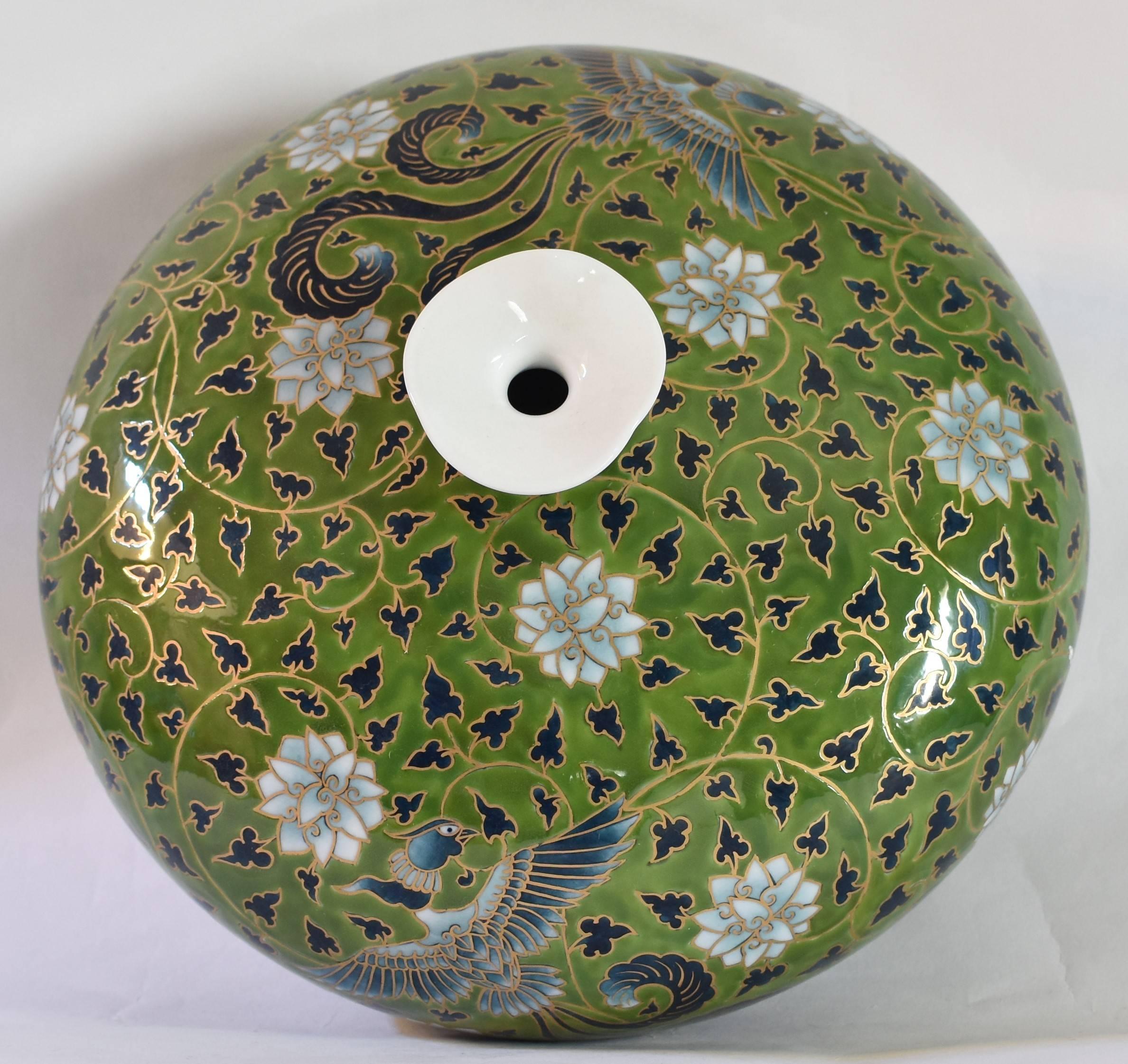 This hand-painted one-of-a-kind contemporary Japanese porcelain vase is presented in an auspicious rotund form and combines an arabesque motif with birds and flowers set against a soothing moss green background. The work is signed by Fujii Katsuma,