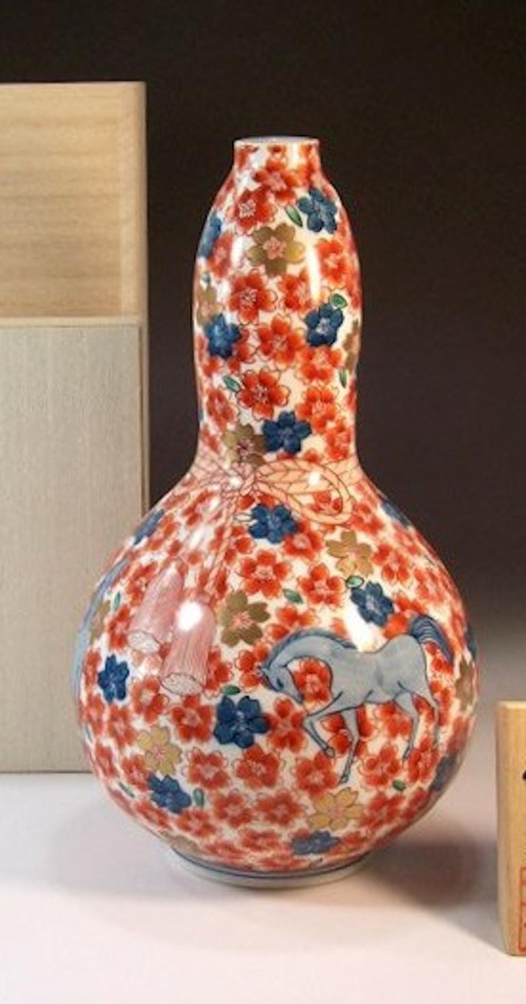 Japanese contemporary decorative porcelain vase, intricately hand-painted in red, blue and pink by acclaimed award-winning master porcelain artist from the Imari-Arita region of Japan.The artist is the recipient of numerous awards for his signature
