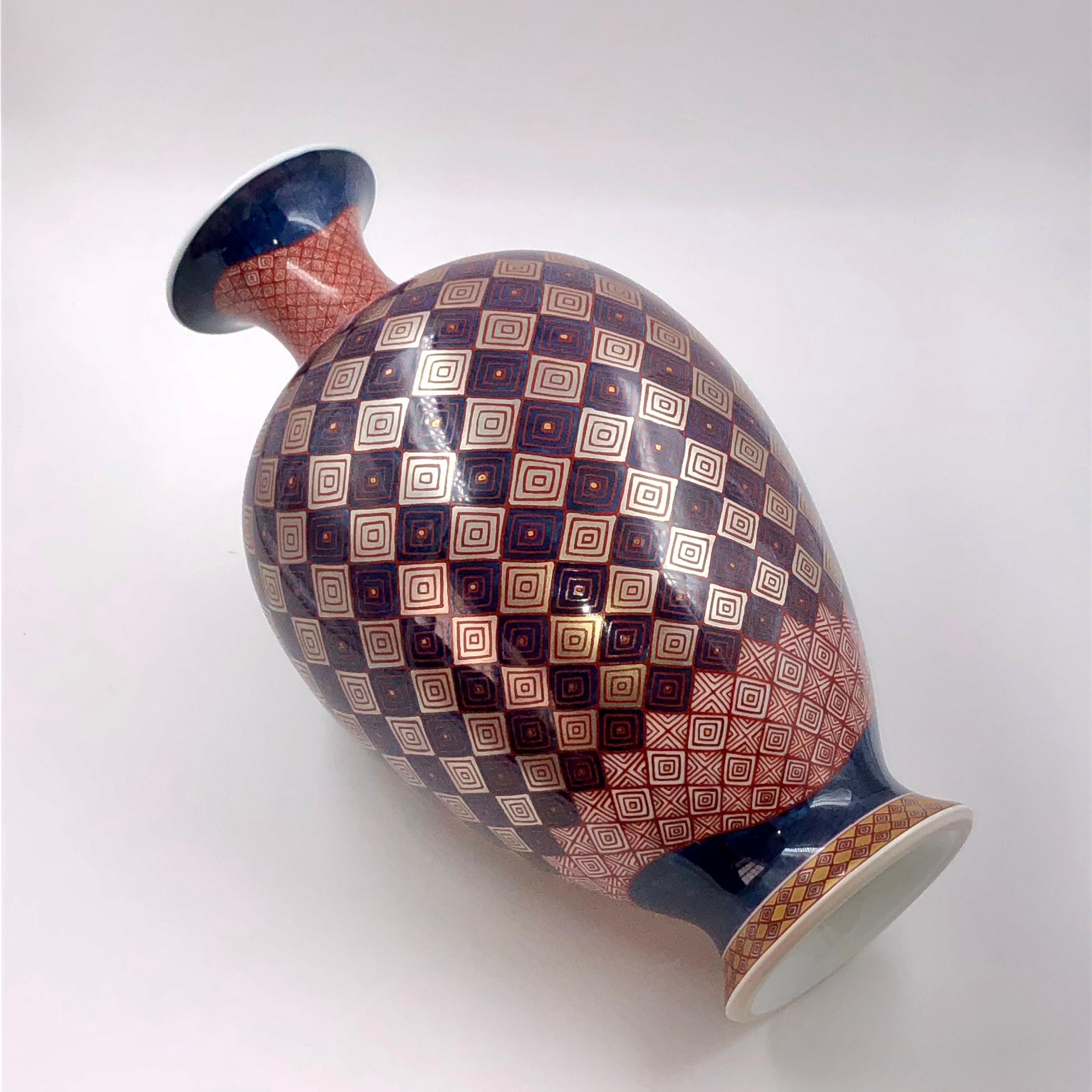 Excepcional jarrón de porcelana decorativa japonesa contemporánea de calidad de museo, con una forma extraordinaria y un fascinante y detallado motivo geométrico en progresión, pintado a mano en rojo, azul y platino de gran pureza, una obra maestra