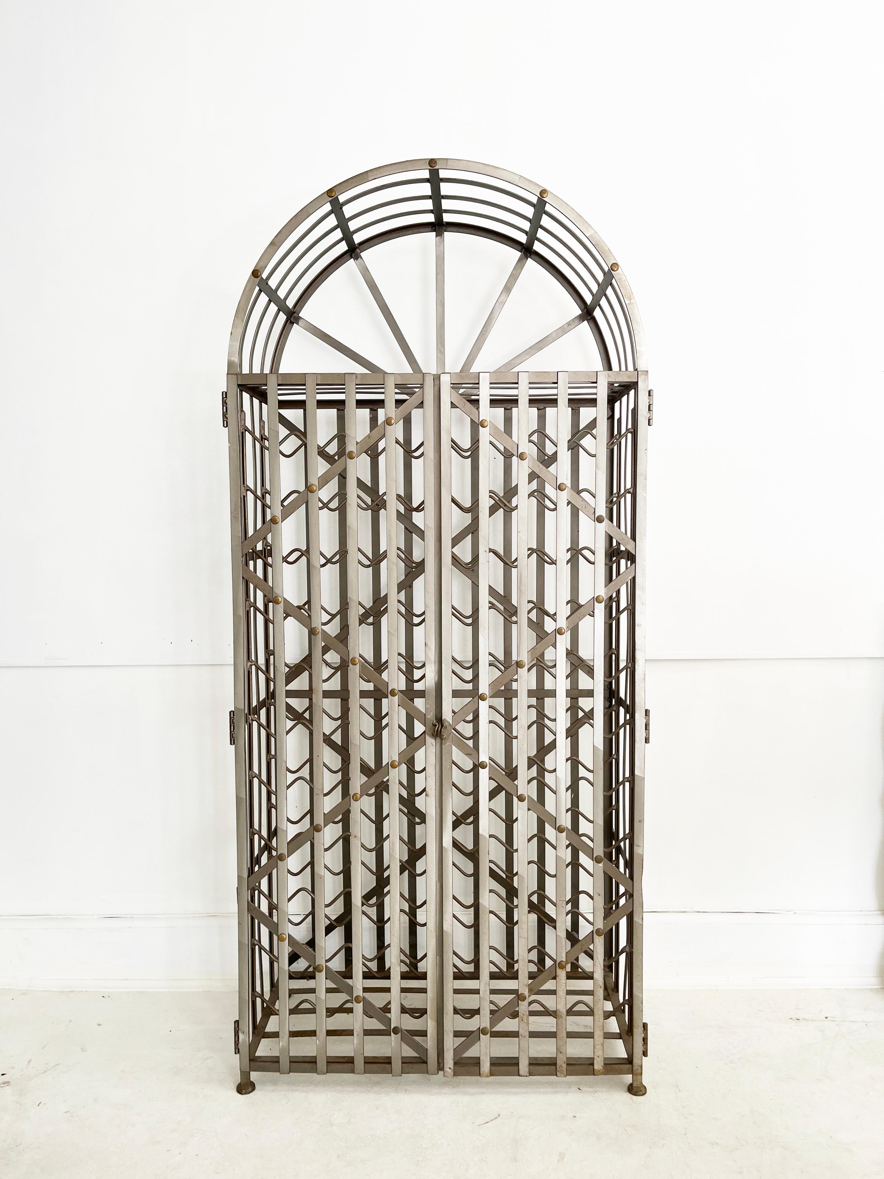 La cage à vin en acier et en laiton fabriquée à la main peut contenir 88 bouteilles de vin et possède des portes à charnières qui peuvent être verrouillées à l'aide d'un cadenas. Fabriqué à la main aux États-Unis en acier avec des rivets décoratifs