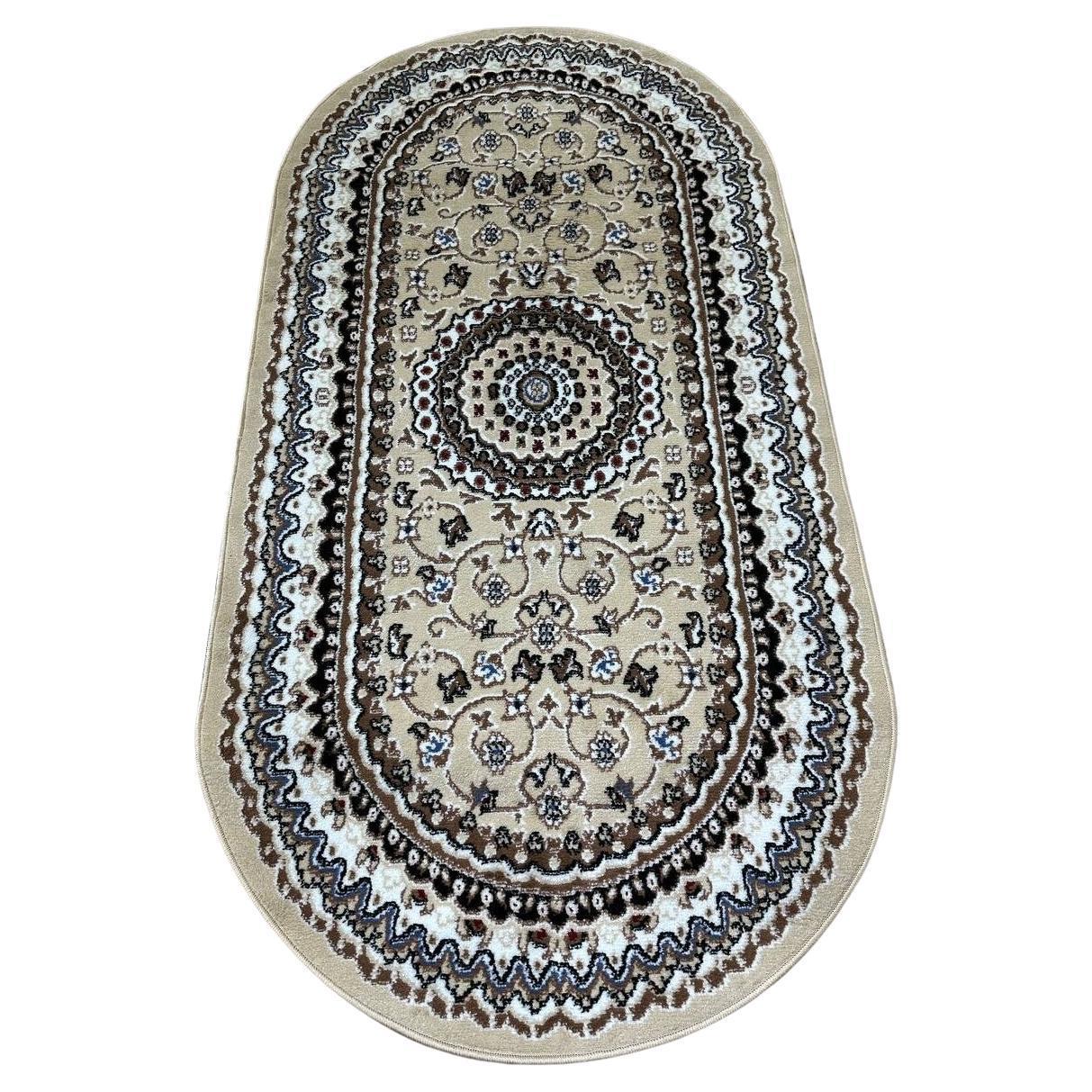 This elegant contemporary Kazakh rug features a classic Tabriz style design with an oval shape, adding a touch of sophistication to any room. Machine-made from a blend of polypropylene and jute, this lightweight rug comes in a refined beige