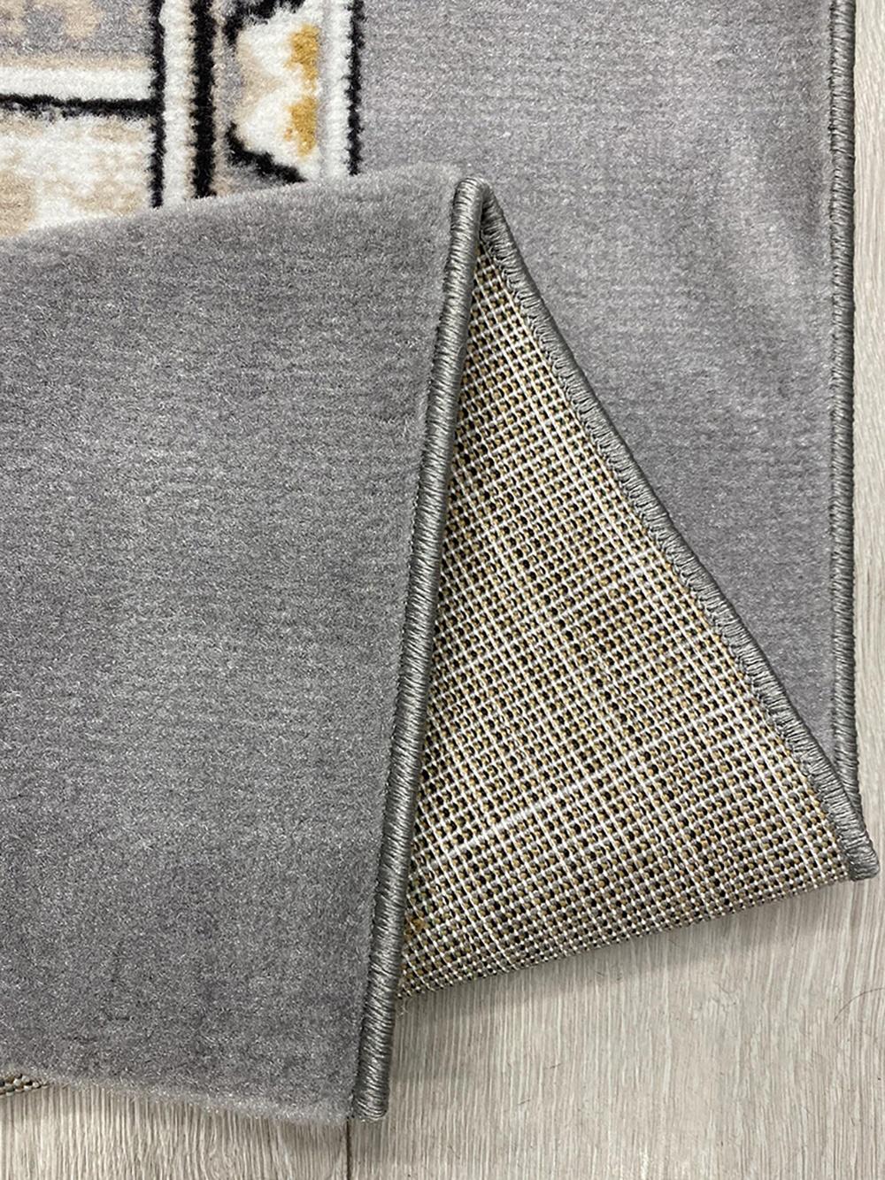 This stylish contemporary Kazakh rug features a modern design with a combination of botanical and geometric patterns. Machine-made from high-quality polypropylene, this lightweight rug comes in elegant beige and gray tones, perfect for enhancing the