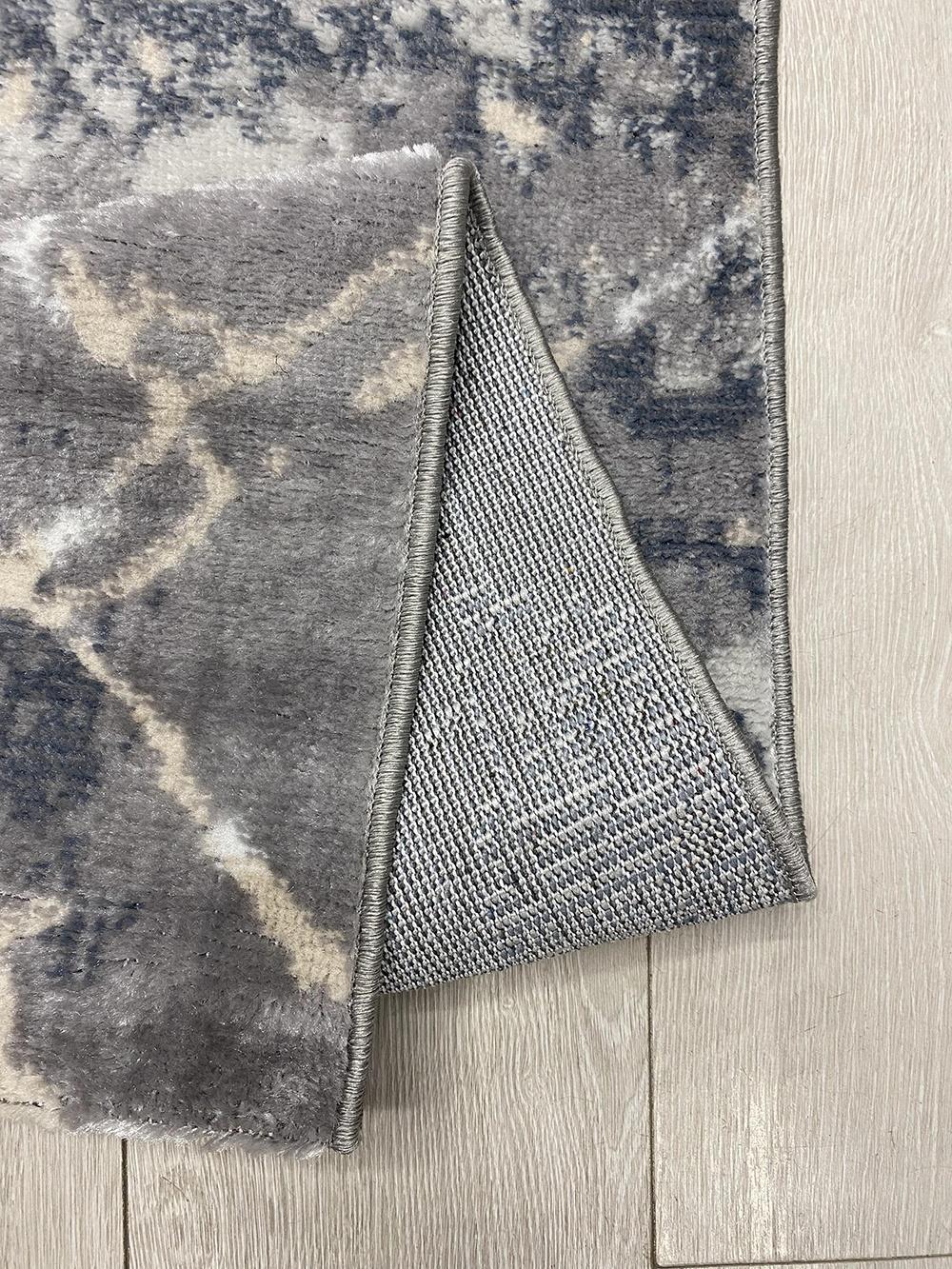 Ce tapis kazakh contemporain présente un design moderne avec un mélange de motifs abstraits et classiques, idéal pour ajouter une touche élégante à n'importe quelle pièce. Fabriqué en machine à partir de polypropylène de haute qualité, ce tapis