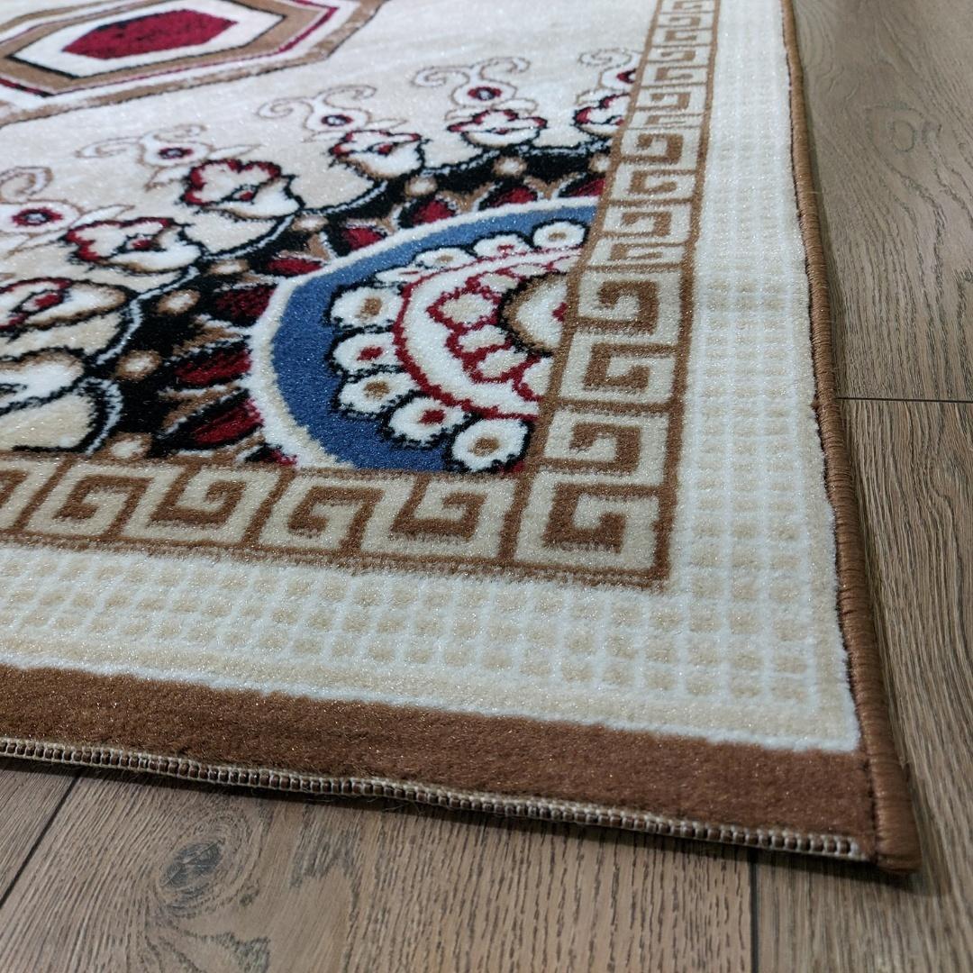 This stylish contemporary Kazakh rug features a modern design with a unique pattern, perfect for adding a touch of sophistication to any room. Machine-made from high-quality polypropylene, this lightweight rug in beige and brown offers both