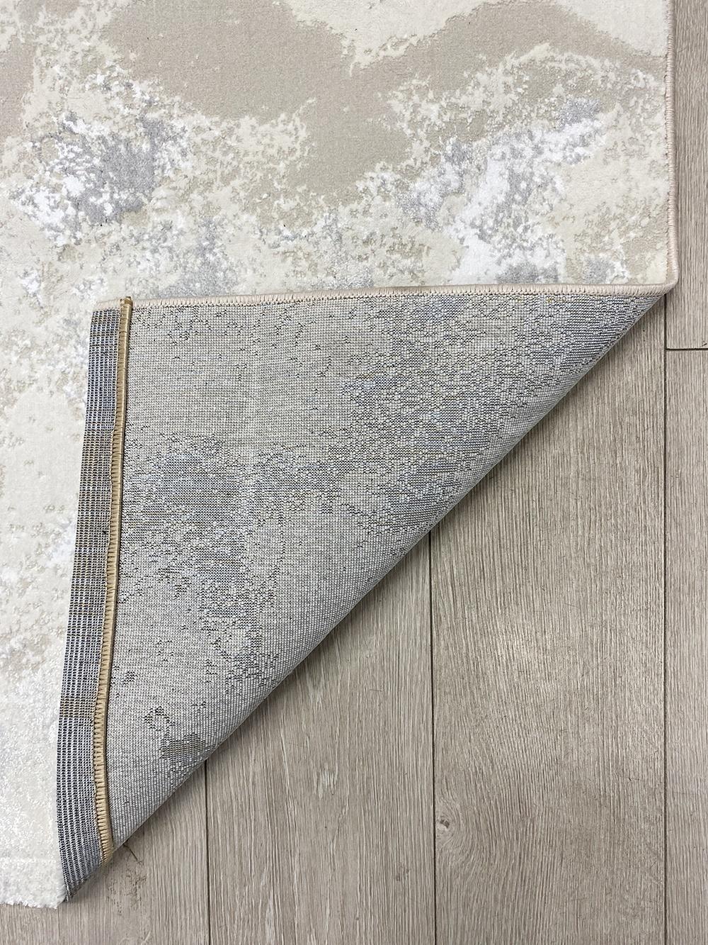 This contemporary Kazakh rug features a modern design with abstract patterns, perfect for adding a touch of elegance to any room. Machine-made from a high-quality blend of polypropylene and polyester, this lightweight rug comes in a versatile white