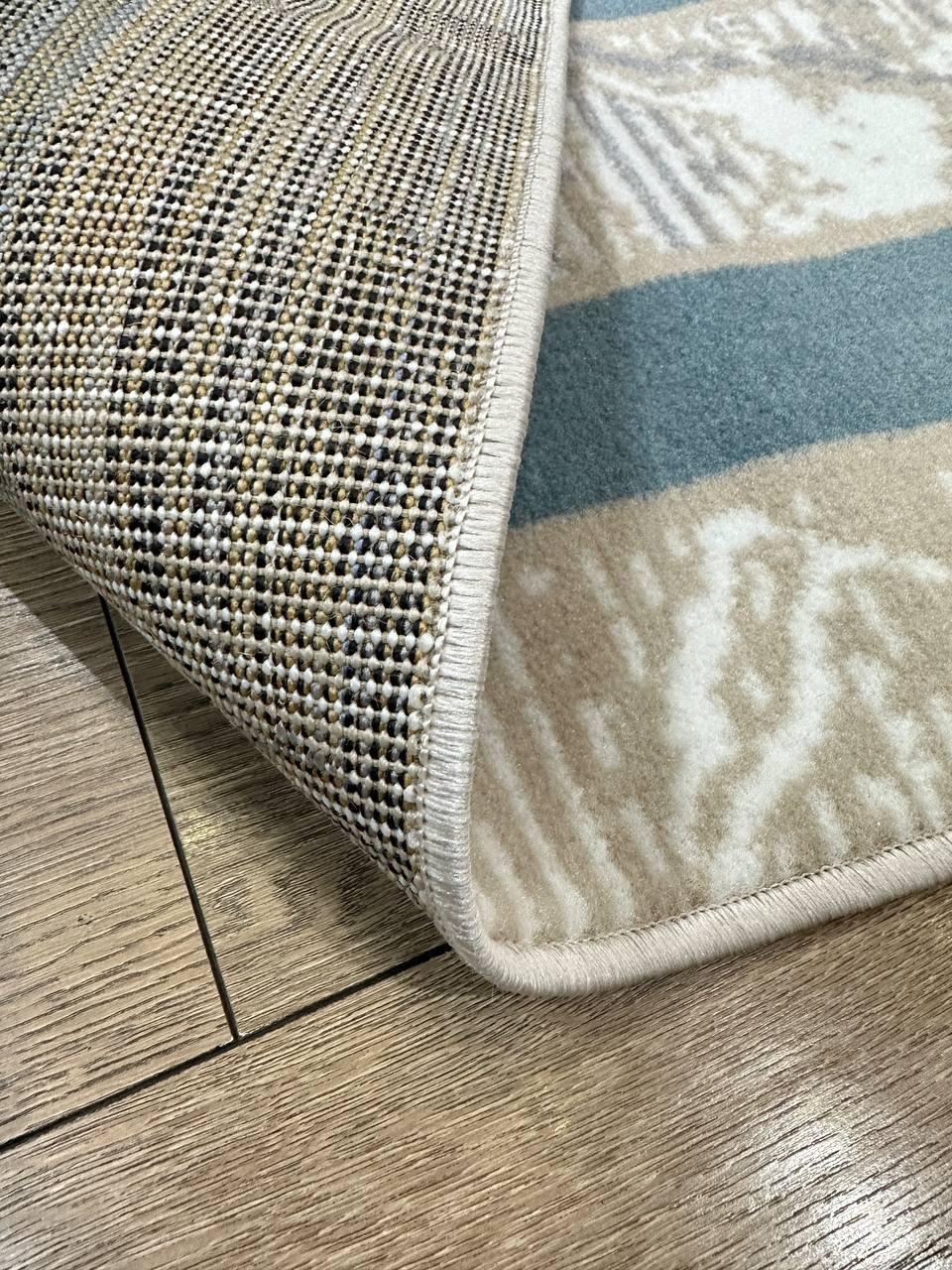 This contemporary Kazakh rug features a modern design with abstract and contemporary patterns, perfect for enhancing any room. Machine-made from a blend of cotton, polypropylene, and jute, this lightweight rug showcases a stylish color palette of