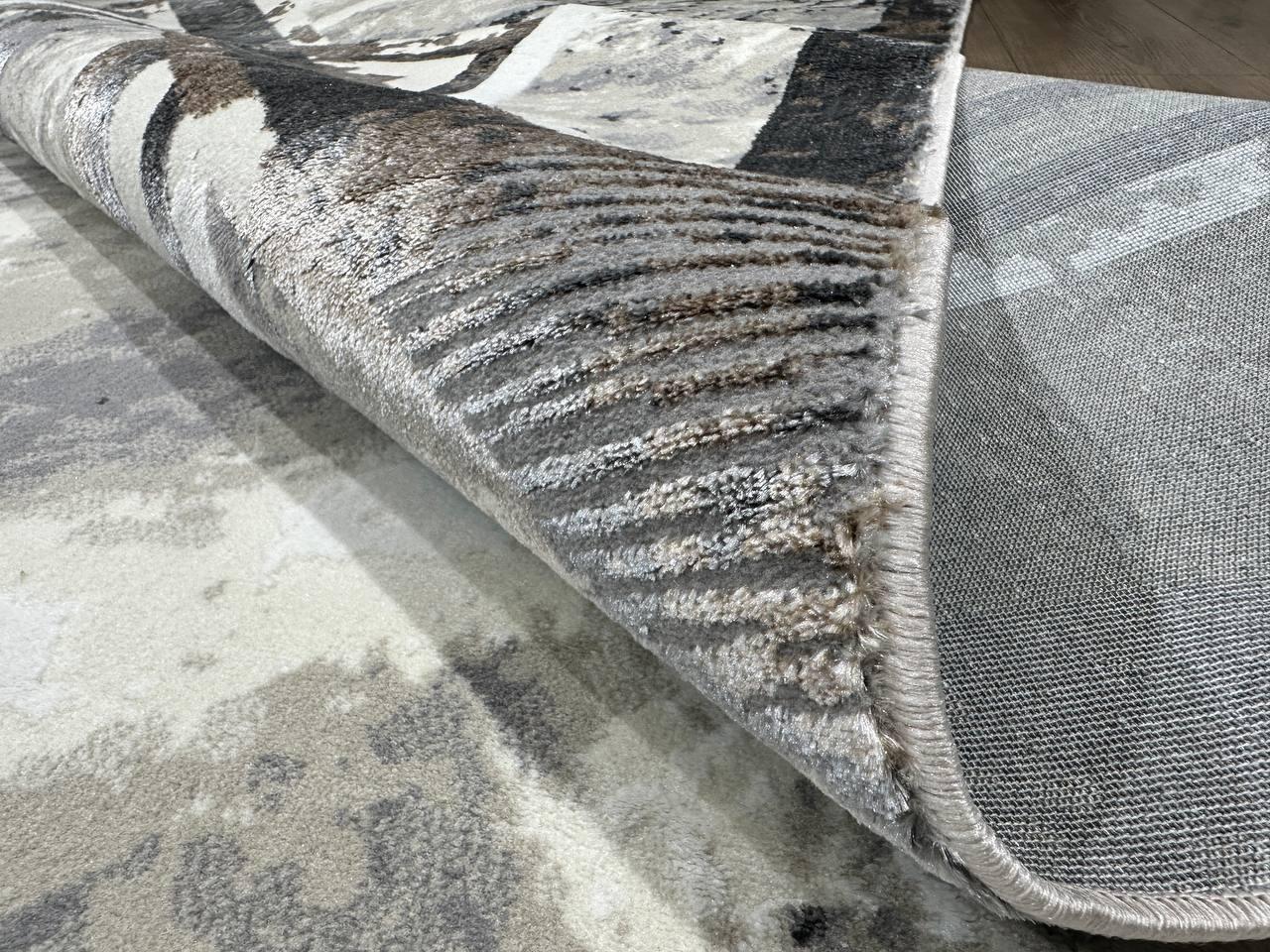 This contemporary Kazakh rug features a modern design with abstract patterns, presented in a generous rectangular shape. Machine-made from a blend of cotton and polyester, this lightweight rug showcases a sophisticated color palette of white, black,