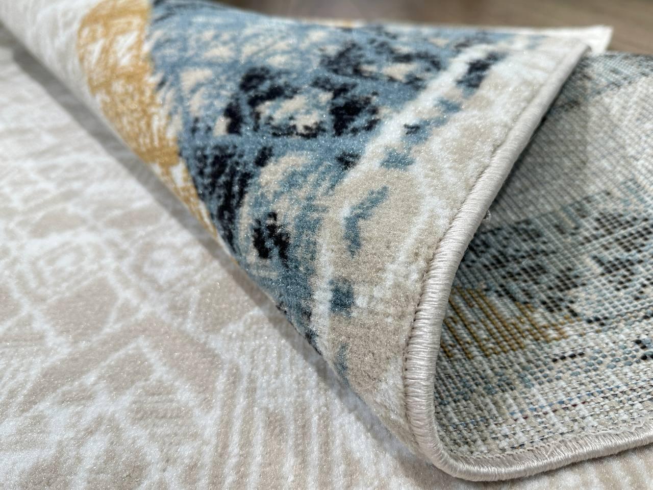 This contemporary Kazakh rug features a modern design with abstract patterns, ideal for enhancing any space. Machine-made from a blend of cotton, polypropylene, and jute, this lightweight rug comes in a sophisticated color palette of blue, cream,