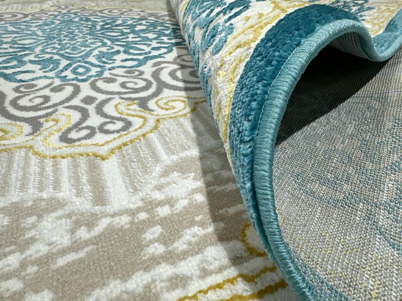 This exquisite contemporary Kazakh rug features traditional Kazakh ornaments in a classic neoclassical pattern. Machine-made from a blend of cotton, polypropylene, and polyester, this lightweight rug showcases elegant gray, turquoise, and cream