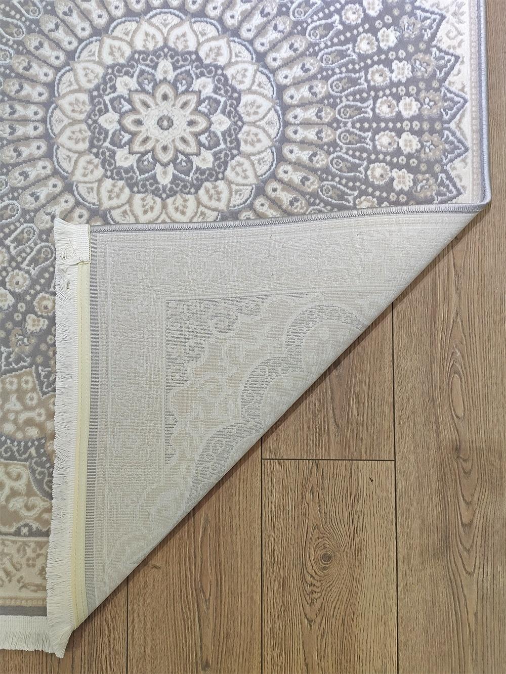 This contemporary Kazakh rug features a modern design with a classic pattern, presented in a versatile rectangular shape. Machine-made from durable polyester, this lightweight rug comes in a refined color palette of gray and beige, making it a