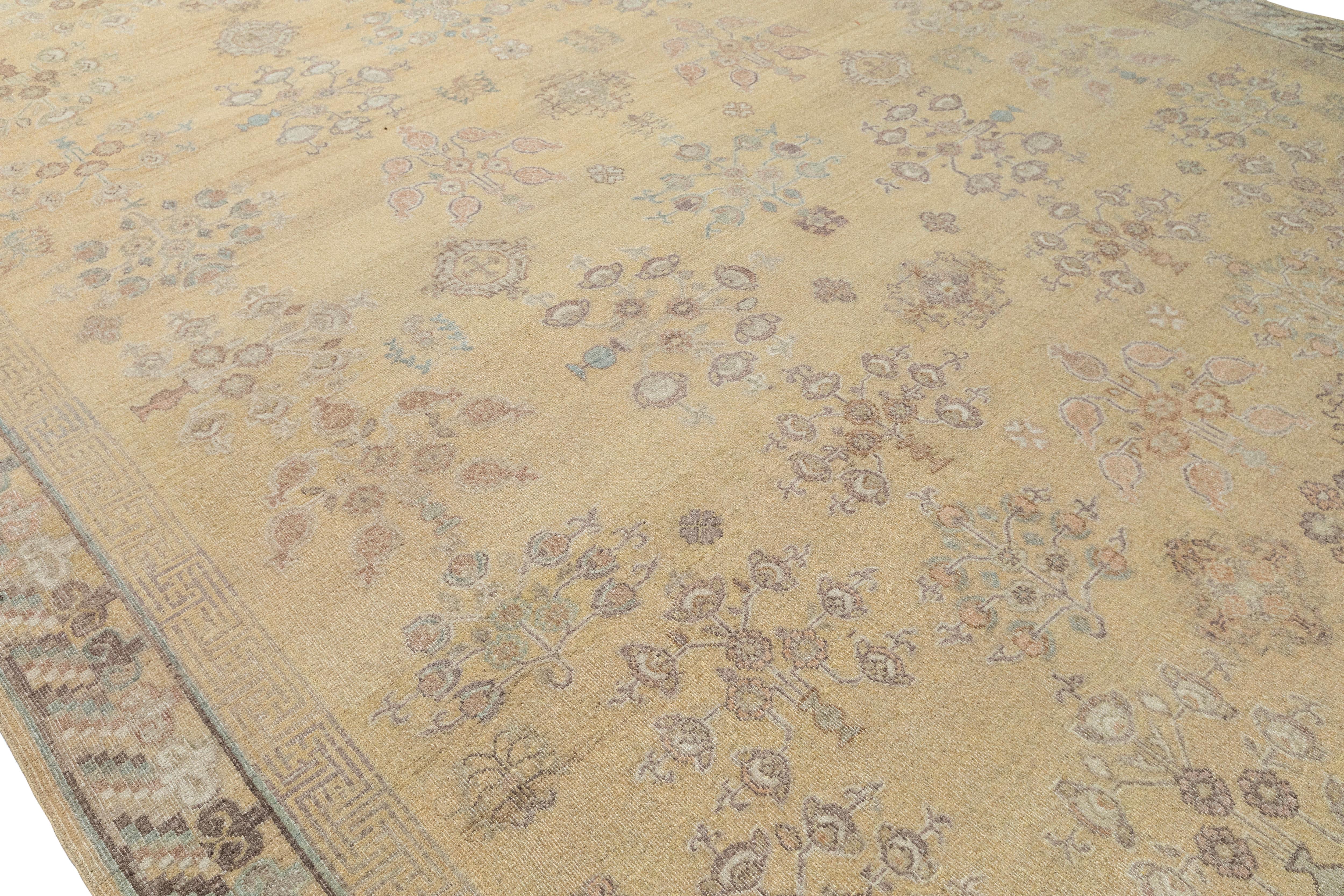 Questo elegante tappeto in stile Khotan è un'interpretazione contemporanea di un classico disegno dell'Asia centrale, caratterizzato da una struttura in lana annodata a mano con un morbido sfondo dorato e delicati medaglioni floreali pastello. I