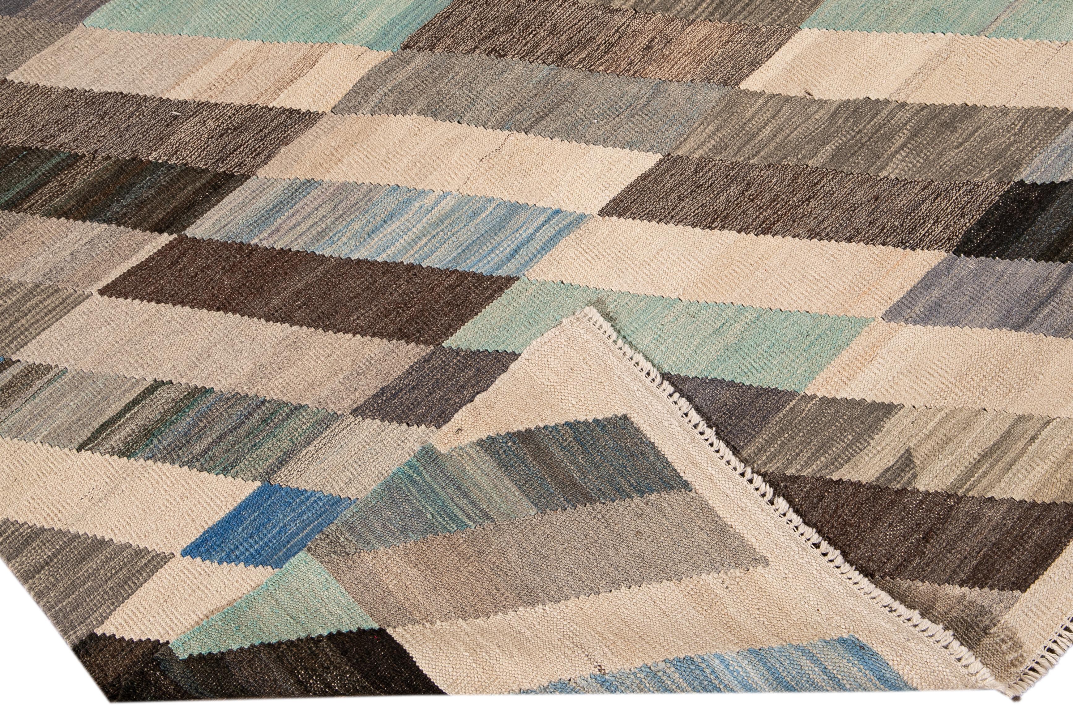 Beautiful modern Kilim flat-weave wool rug. This Kilim rug full of art has a brown, green, and blue field in a gorgeous geometric abstract design.

This rug measures: 8' x 11'6