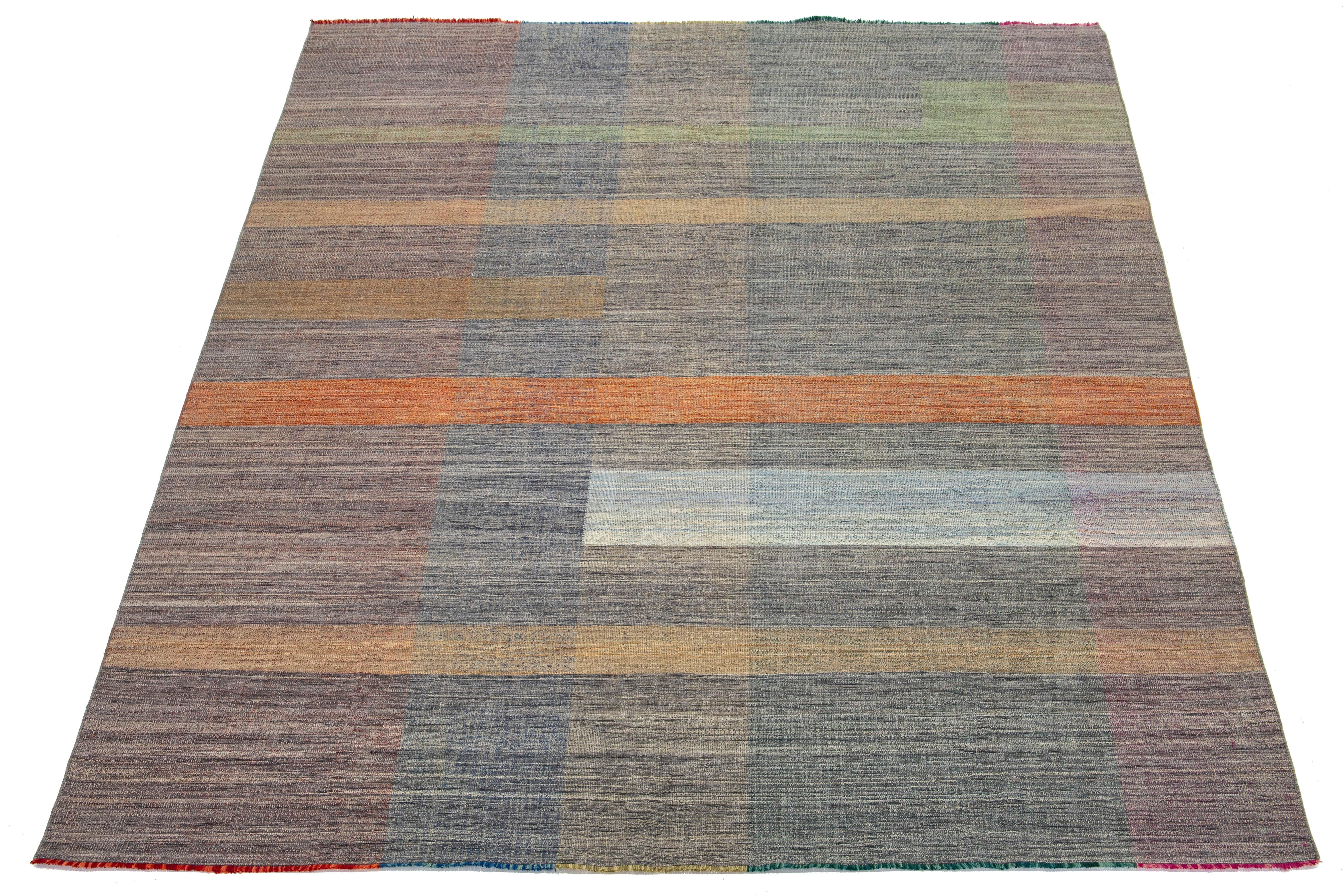 This rug features an organic modern design with a wool Kilim flatweave, showcasing a geometric pattern in vibrant hues of orange, green, blue, and pink.

This rug measures 10'2