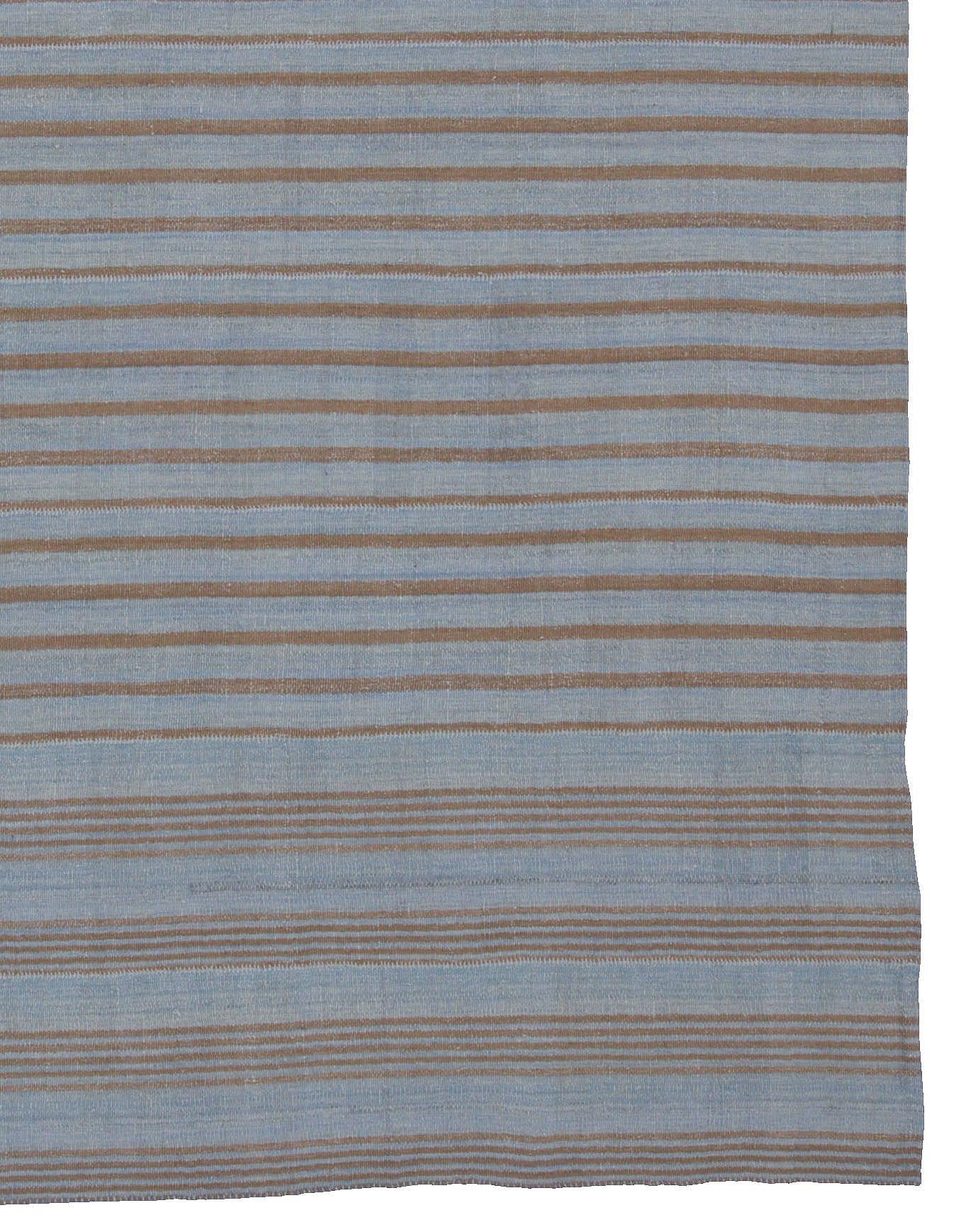 A new production Turkish rug handwoven from the finest sheep’s wool and colored with all-natural vegetable dyes that are safe for humans and pets. It’s a traditional Kilim flat-weave design featuring a robust blue field with brown stripes. It’s a