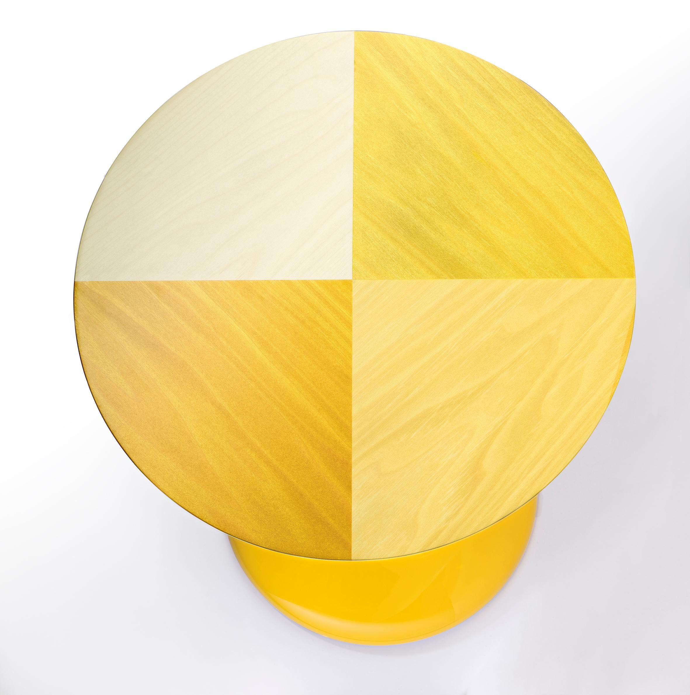 Ein dekoratives Guéridon, ganz aus Blockmaterial gedreht und mit Hochglanzlack in Goldgelb RAL 1004 lackiert.
Die Decke ist mit klarem Ahornholz und verschiedenen gelb gefärbten Holzarten mit einem subtilen Holzrichtungswechselmuster