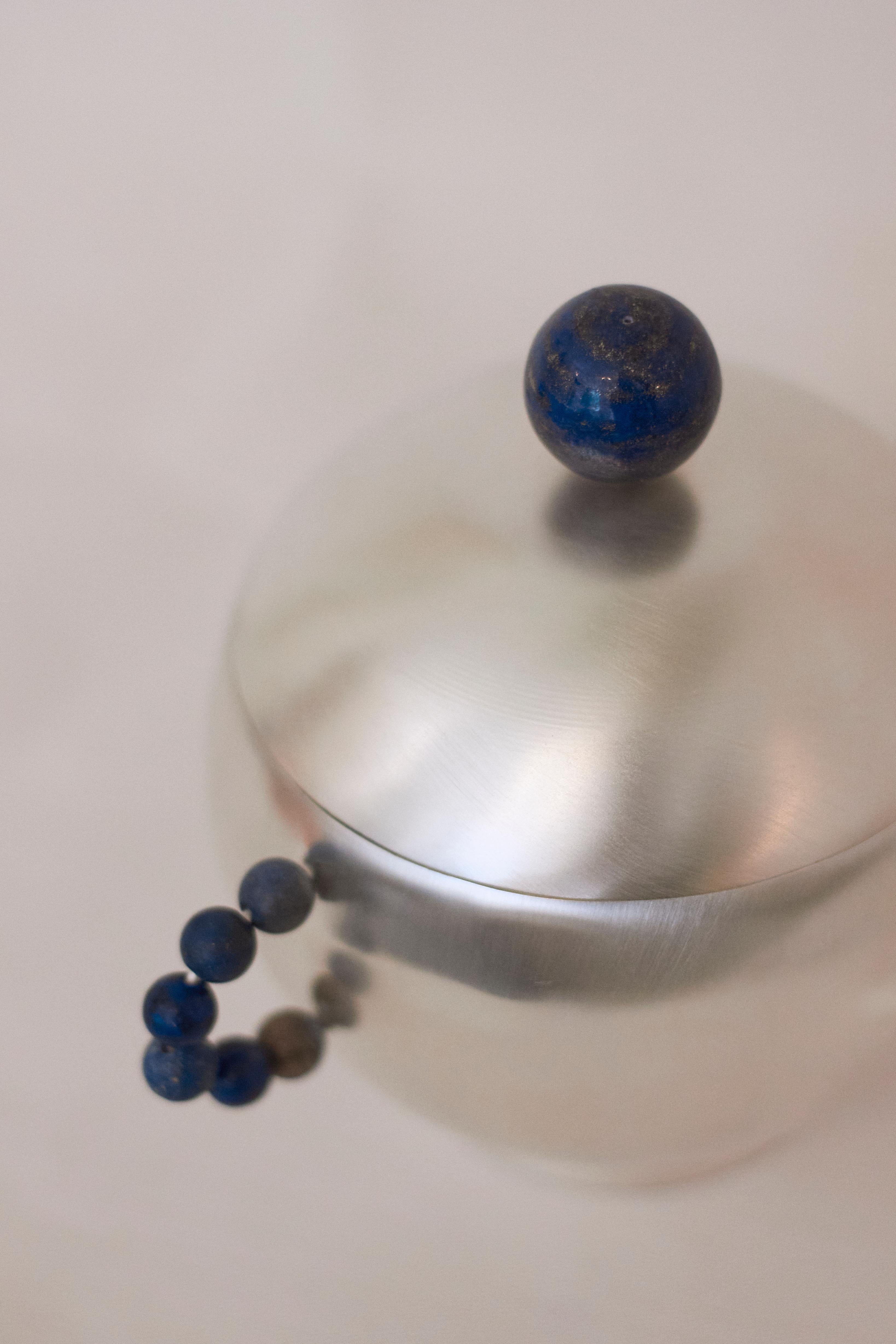 Elevate your dining experience with the sugar perlina, a plated brass container expertly crafted in Italy using sheet turning techniques.  The curved handles and top are adorned with lapis lazuli stones, adding a touch of jewelry inspired
