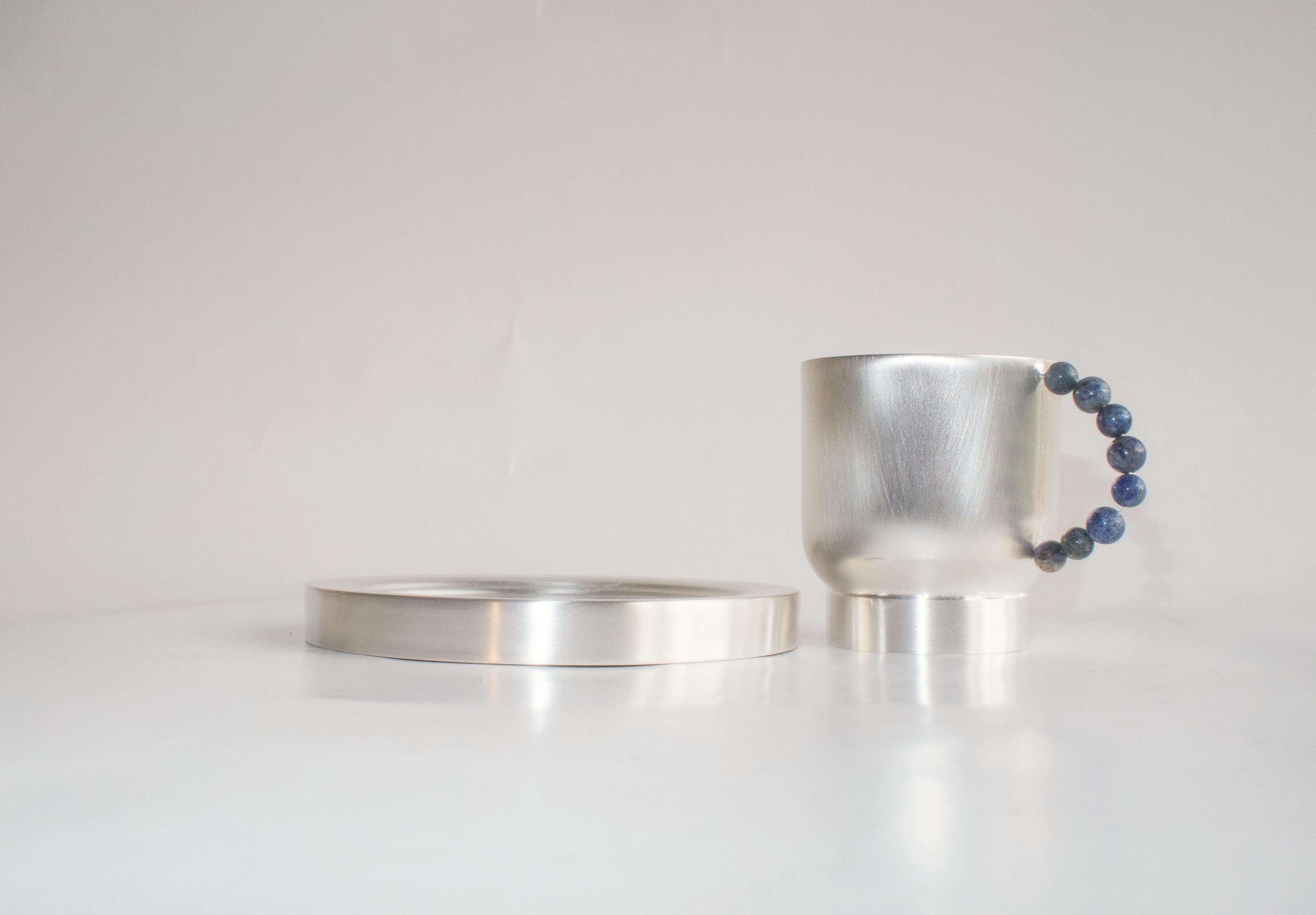 Elevate your daily tea or coffee ritual with our  perlina cup and piattino. The plated brass cup and plate are handcrafted in italy using sheet turning techniques. The handle, adorned with a row of lapiz lazuli  or white stones, introduces a touch