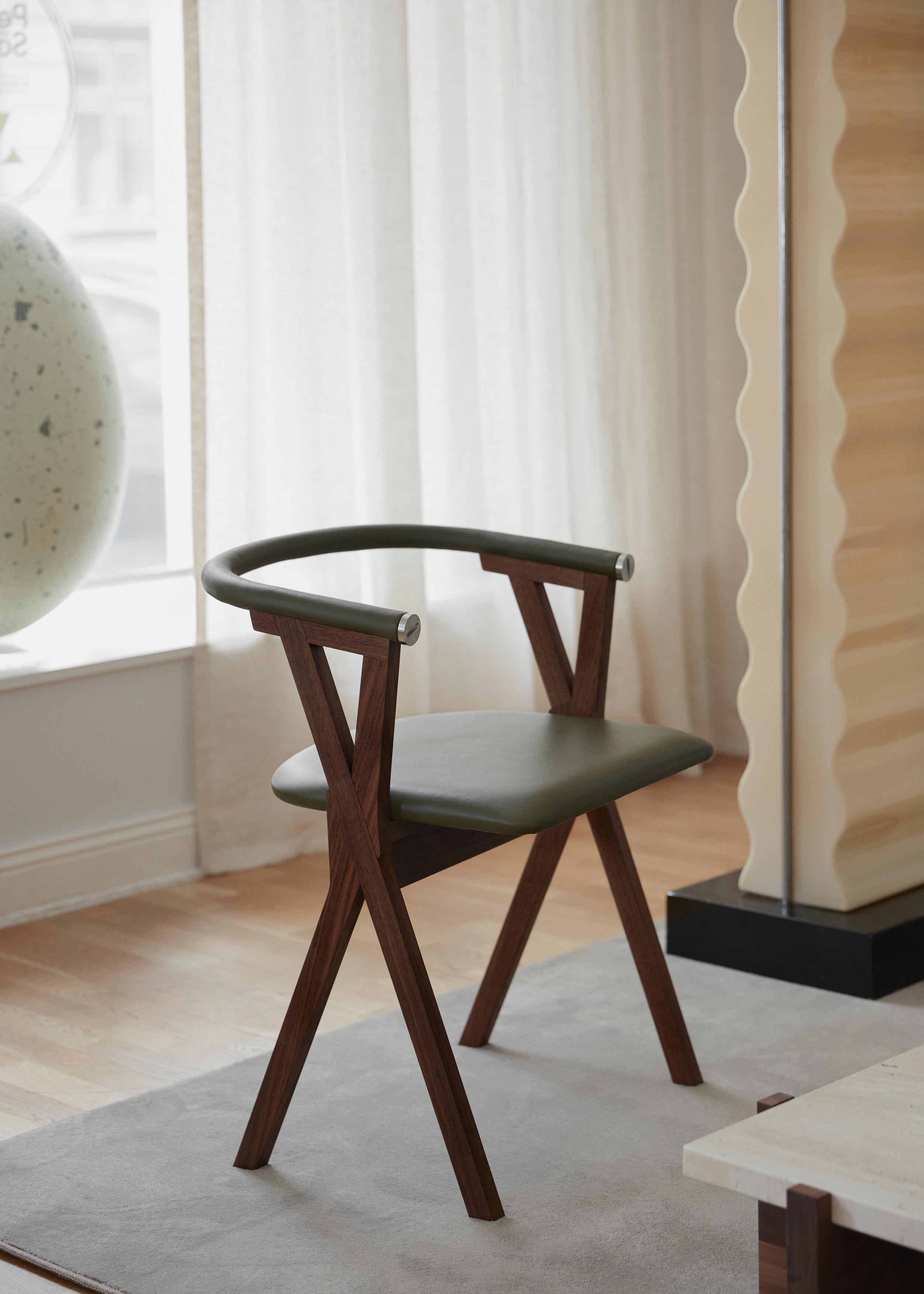 This contemporary Scandinavian dining chair is handmade in Sweden using the finest materials such as massive American walnut, Swedish vegetable tanned leather and details in stainless steel. Designed by Per Soderberg in 2020 for No Early Birds / PS