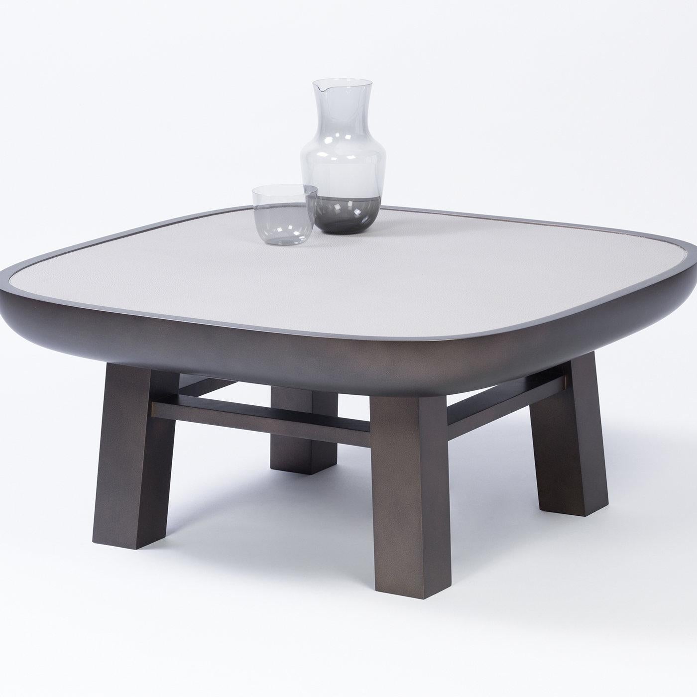 Contemporary leather coffee table - Olympia by Stephane Parmentier for Giobagnara. 
The object presented in the image has following finish: F10 light blue nappa leather and bronze-laquered wood.

This captivating coffee table is part of the