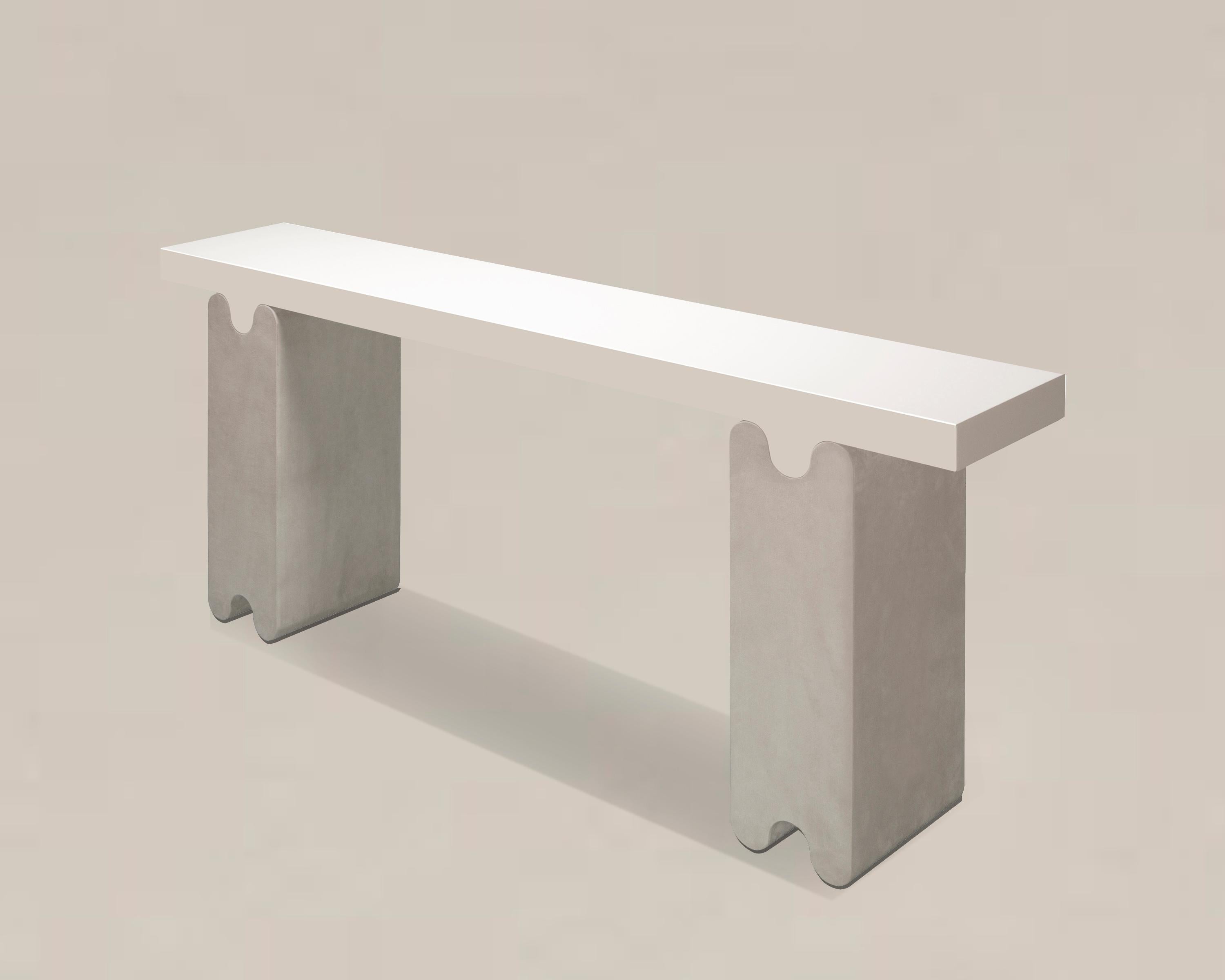 Contemporary leather console - Ossicle by Francesco Balzano for Giobagnara.
The object presented in the image has following finish: F95 Off White Nappa Leather (top) and A37 Light Grey Suede Leather (legs).

Part of an exquisite series of benches,
