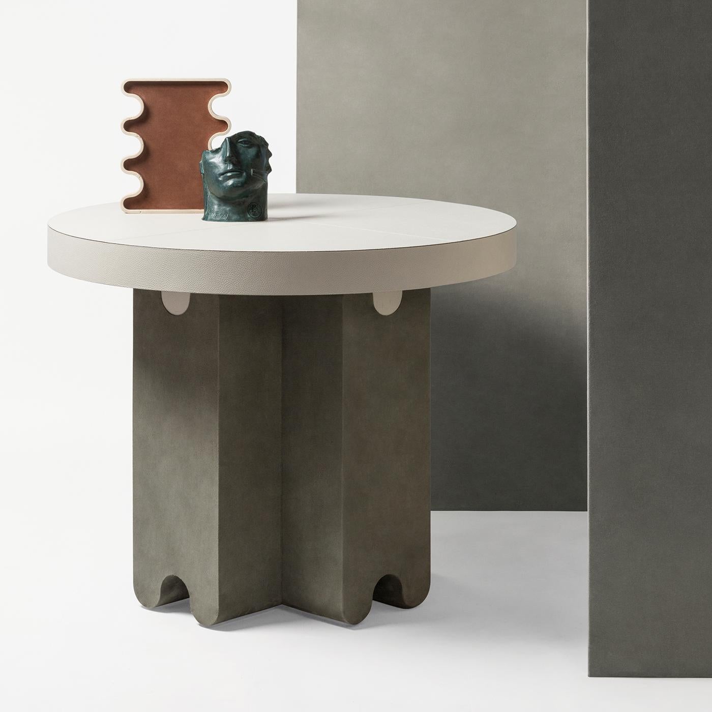 Contemporary leather side table - ossicle by Francesco Balzano for Giobagnara.
The object presented in the image has following finish: F95 Off white nappa leather (top) and A69 sage suede leather (base).

Ossicle is a collection that comprises