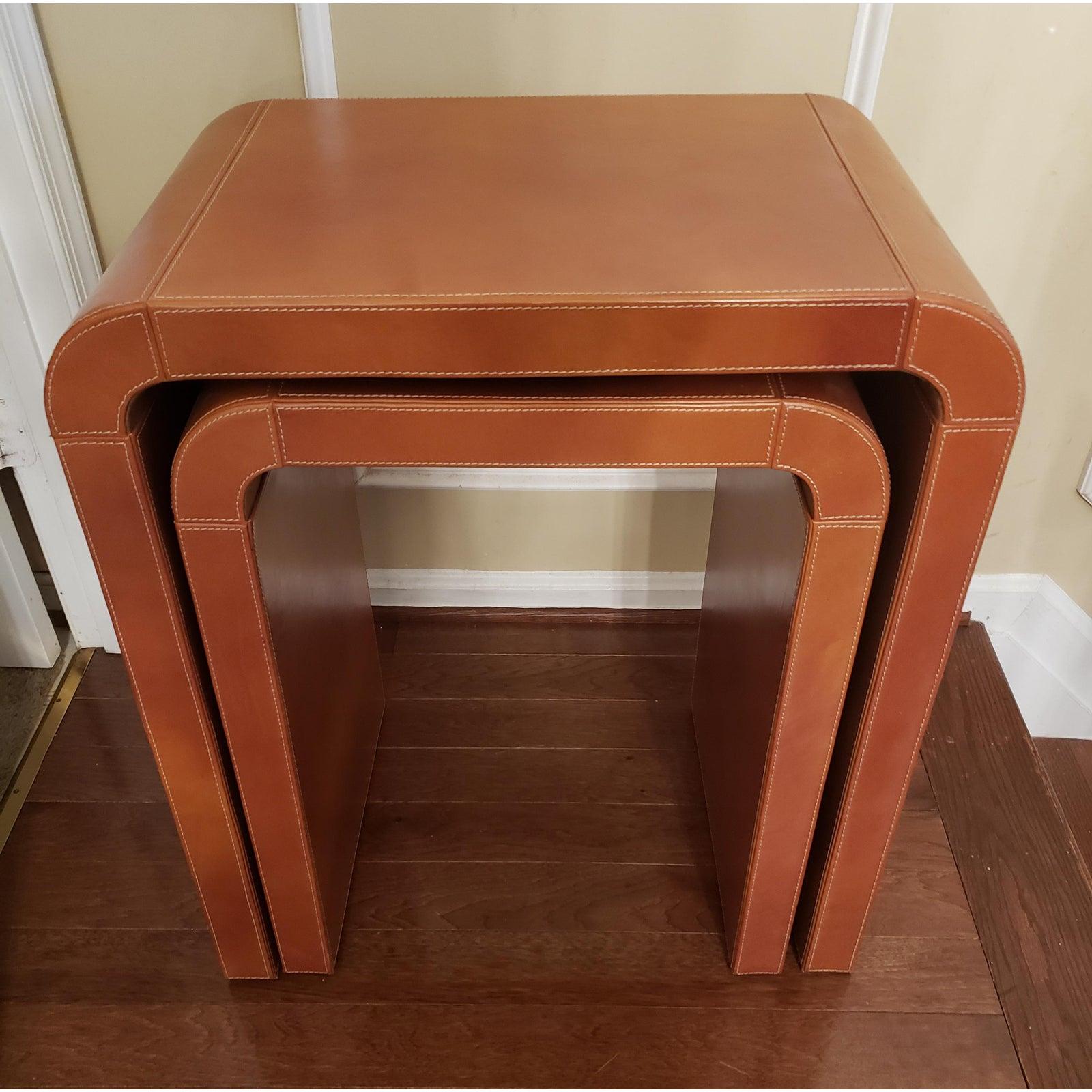 Nesting of waterfall tables in full grain leather. Tan in color. Larger table measures 24WX15DX24H and the smaller table 20W X15XD 24H
Very good condition with some signs of use.
 