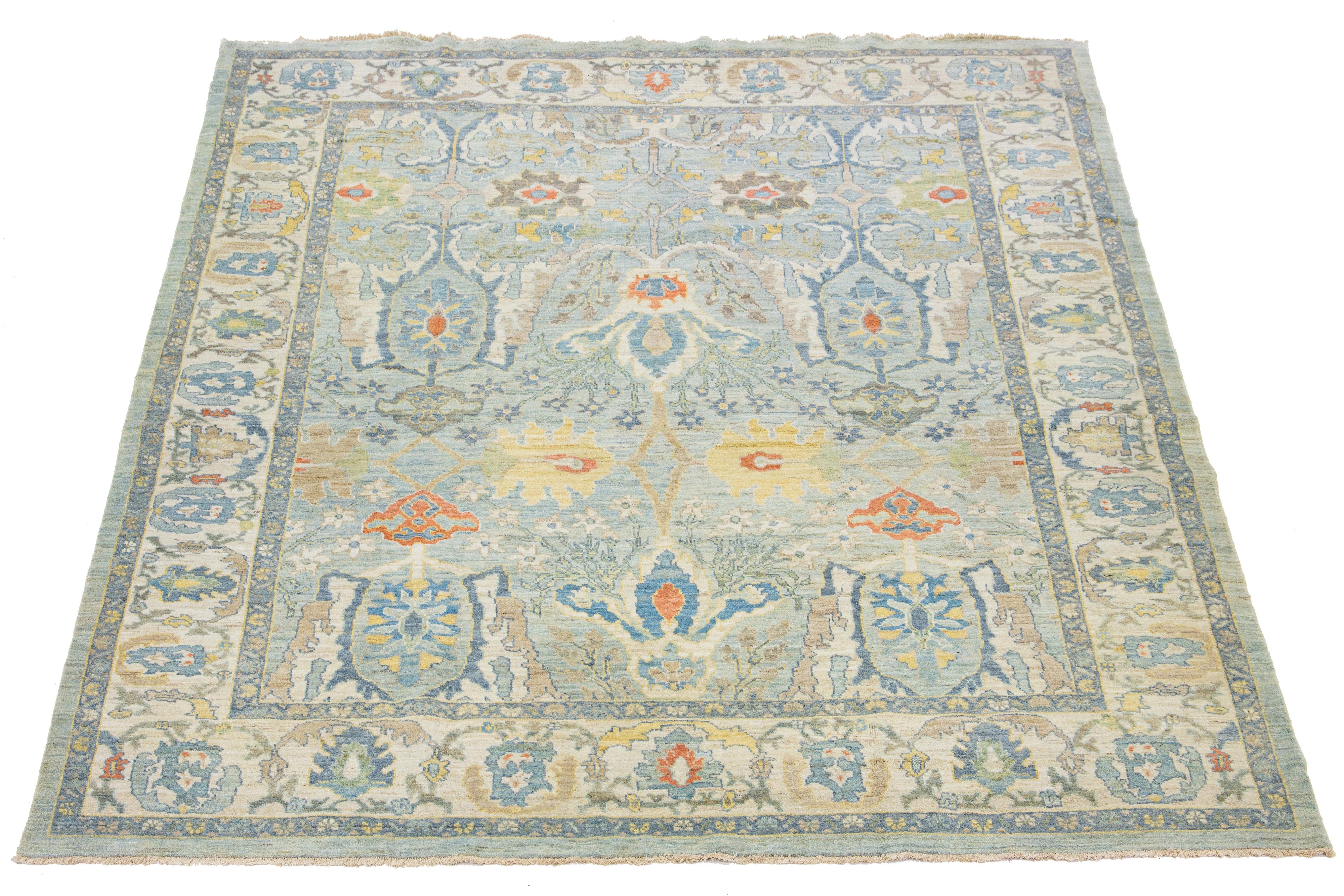 Beautiful room-size modern Sultanabad hand-knotted wool rug with a light blue field. This Sultanabad rug has a beige frame and yellow, orange, and green accents in a gorgeous classic floral pattern.

This rug measures 10'1