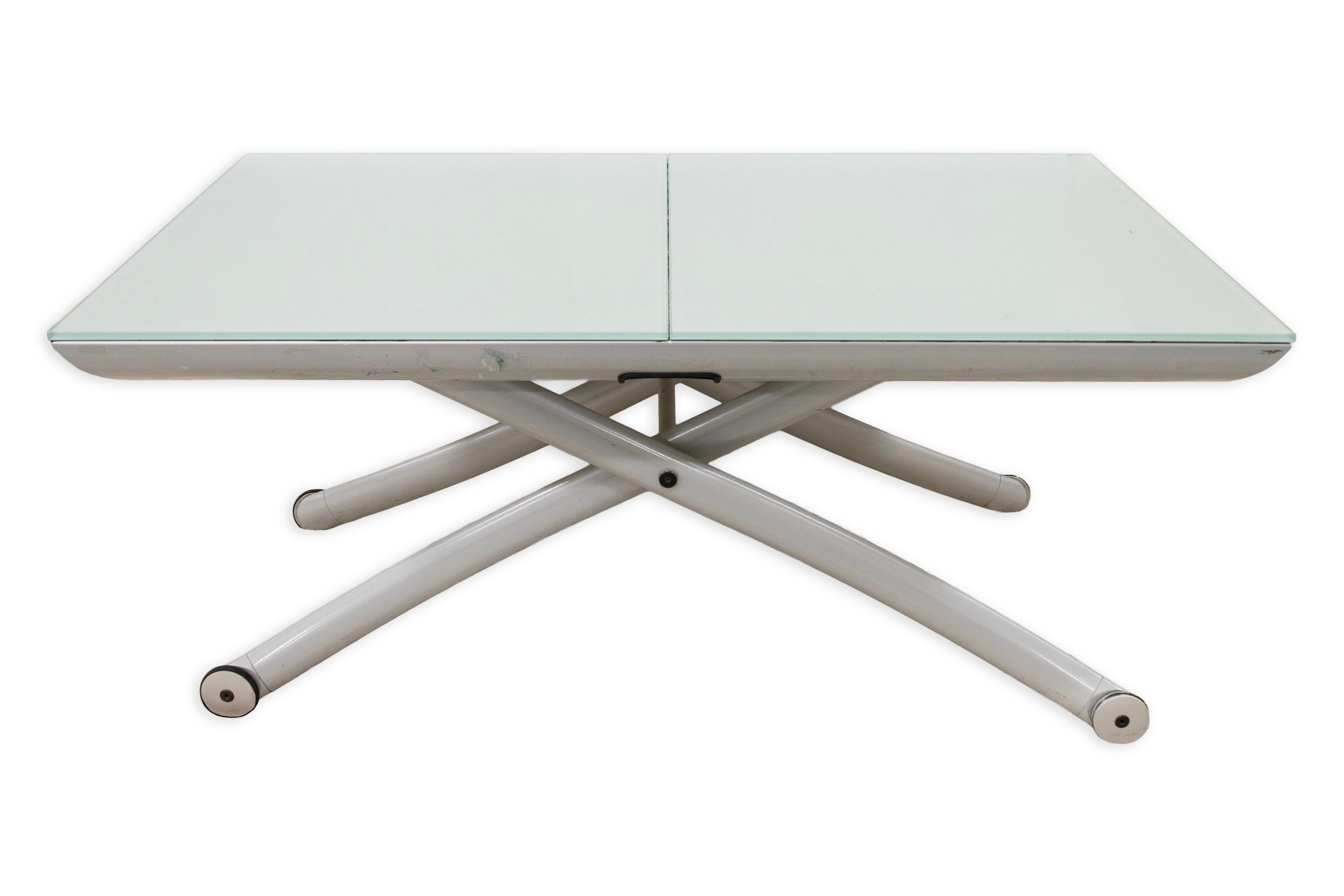 This is a Ligne Roset Yoyo adjustable coffee and dining table that features an extendable top, showcasing a modern design with sleek and functional qualities. The table has a glass tabletop set on a sturdy metal frame, with a base that easily