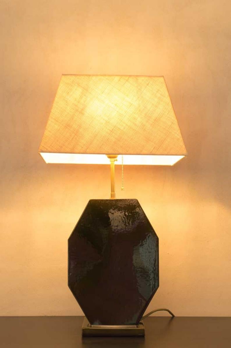 Cette lampe de table est réalisée en céramique, par un spécialiste de la poterie traditionnelle, avec un extérieur vitrifié pour une meilleure projection de la lumière. L'abat-jour et l'ampoule ne sont pas inclus, mais nous pouvons les vendre