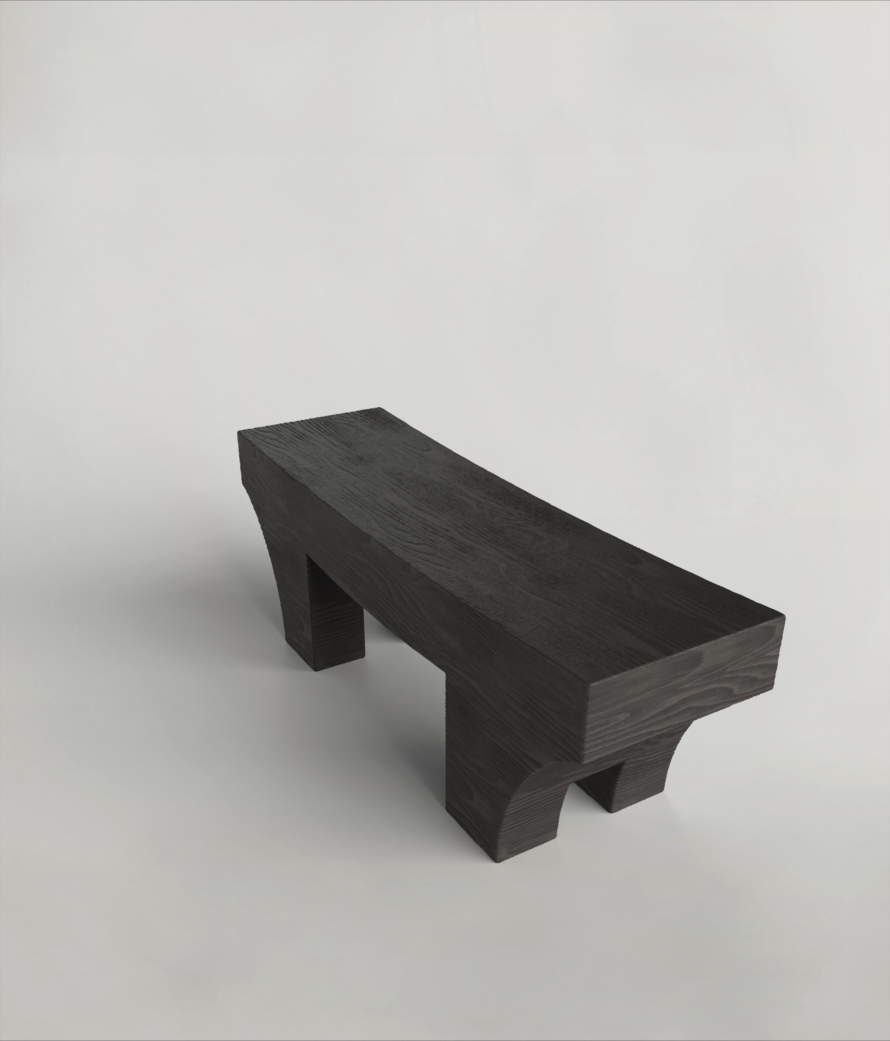 This 21st Century black bench is a product of Italian craftmanship, starting entirely from all-hardwood, the craftsmen sculpt Mhono V2 and then char the wood using the Shou Sugi Ban technique. It is manufactured in a limited edition of 150 signed