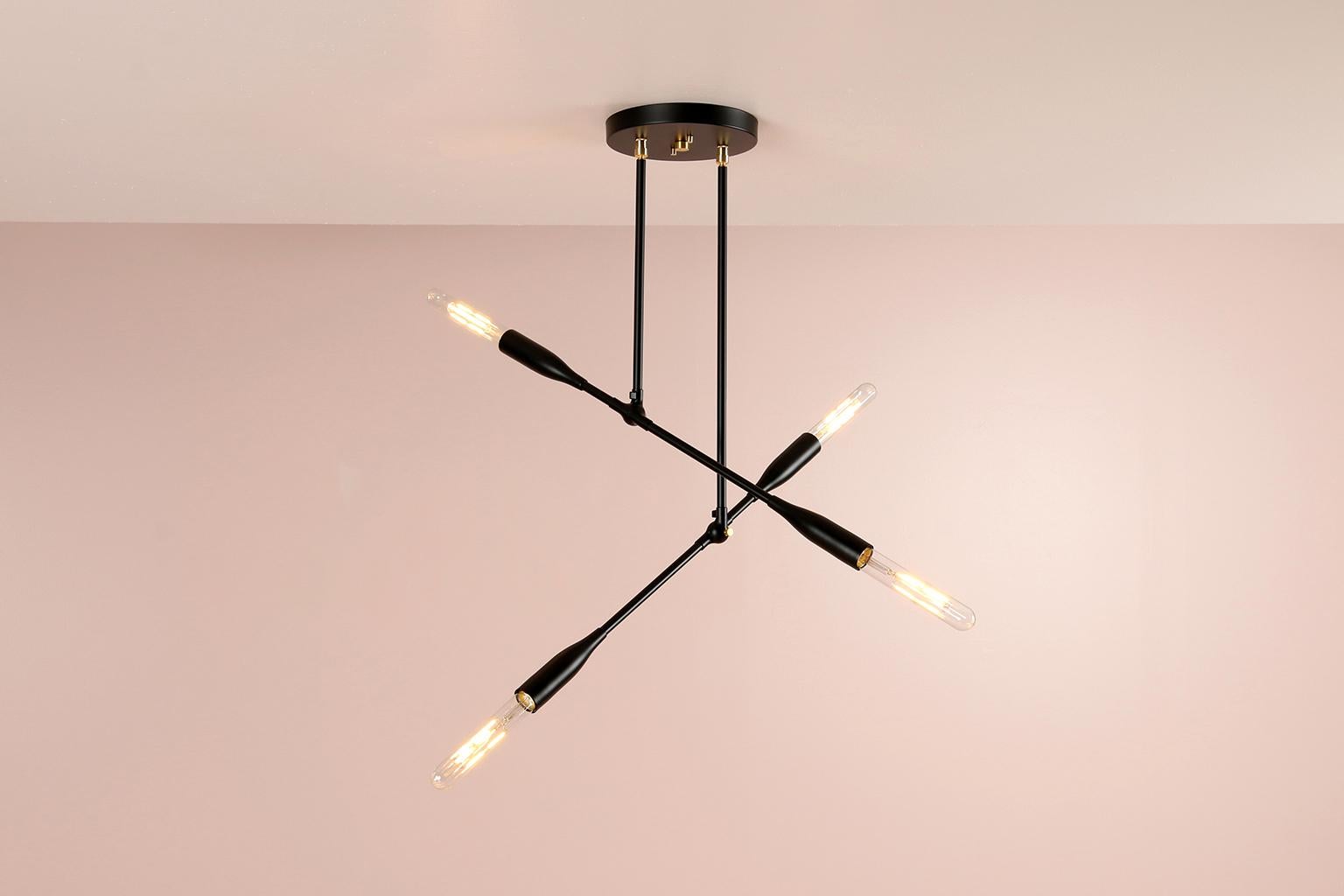 This articulating light fixture works perfectly in small spaces. The modern, linear pendant has bold, elegant lines and dramatic negative space. Hand assembled in our New England studio, the custom light fixture features two lighting arms that can