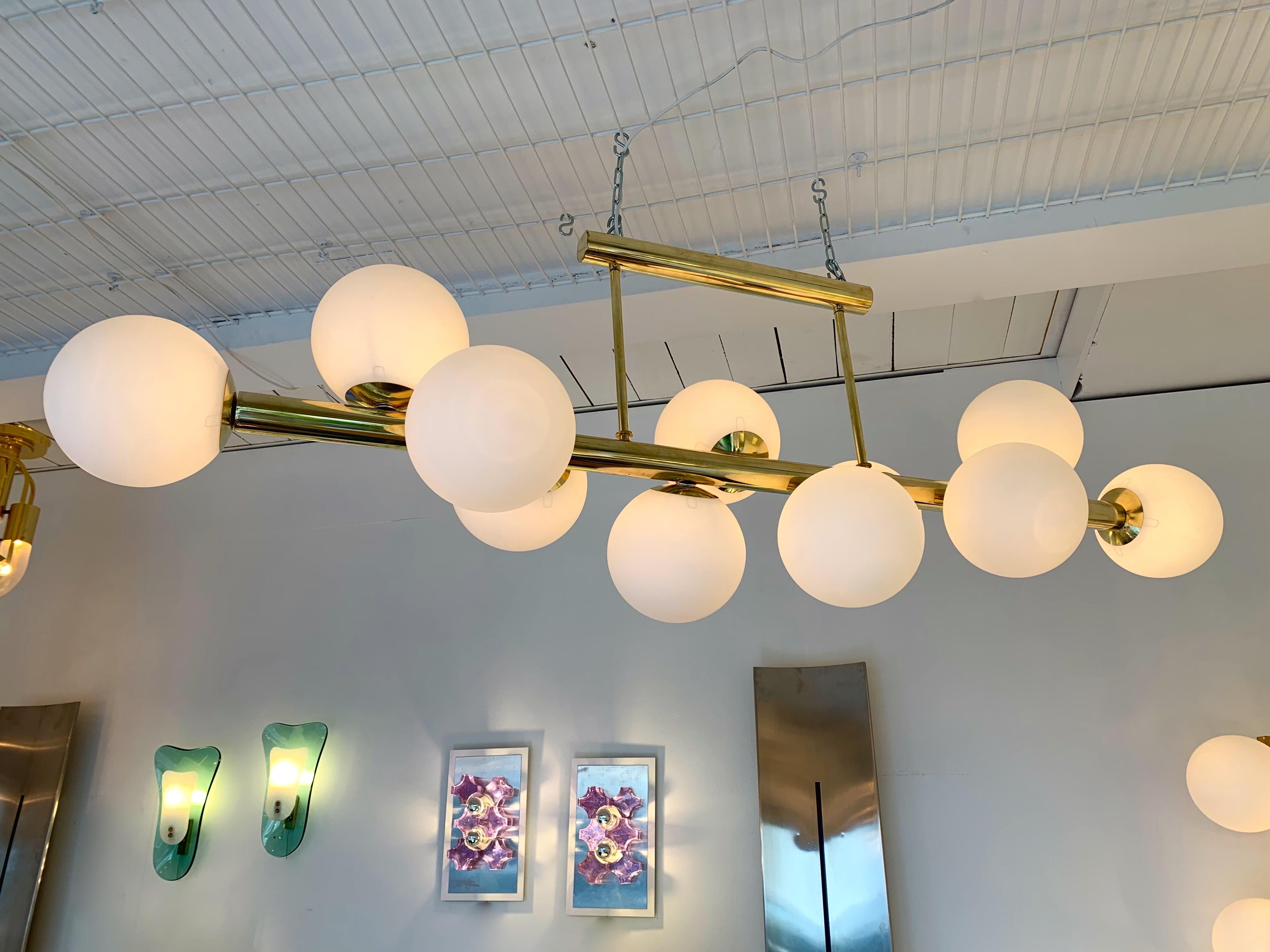 Belle taille de lustre pendentif de plafond en laiton plein et boule en verre opalin de Murano. Une bonne forme pour couvrir une table à manger. Petit atelier italien, peu de production.