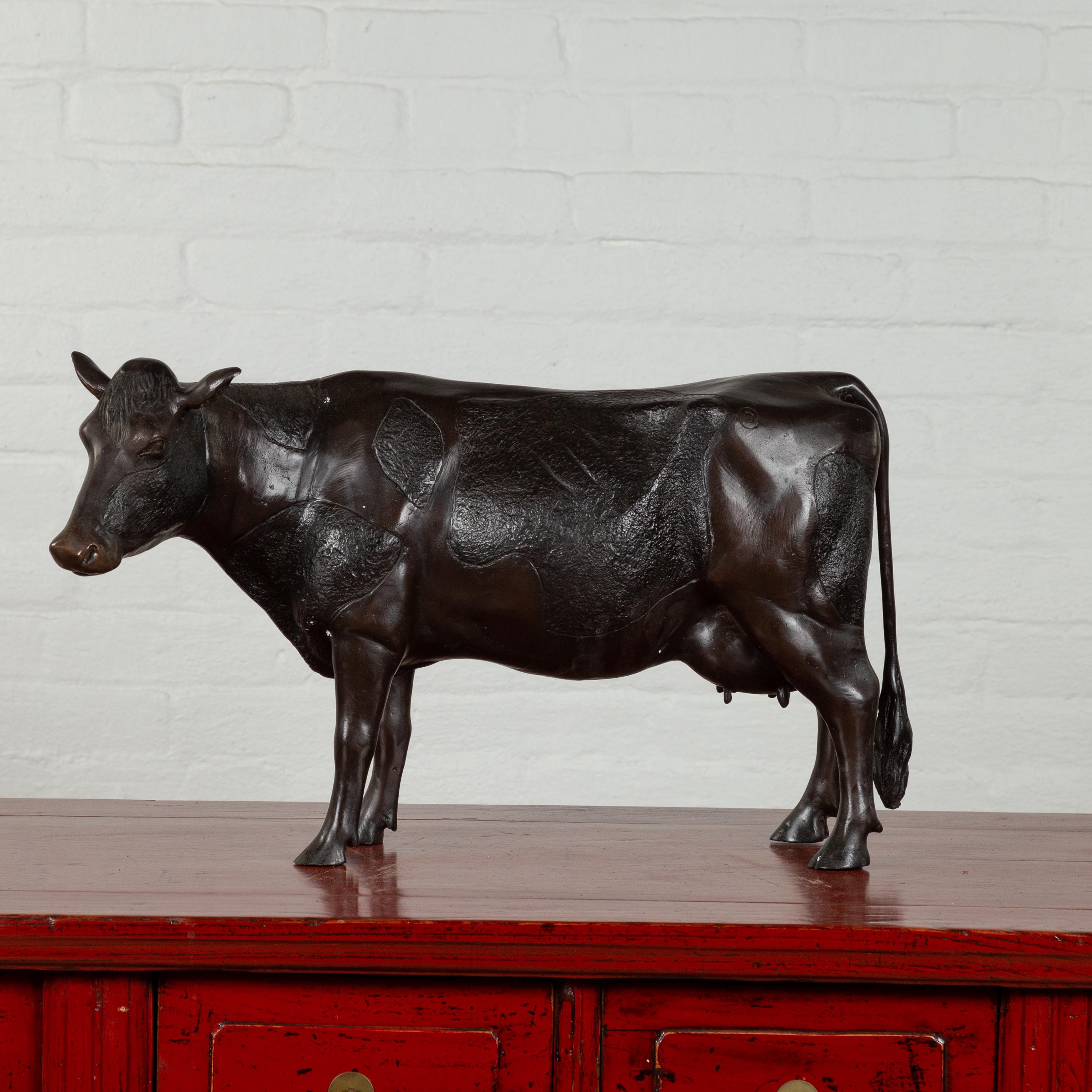 A contemporary cast bronze custom made sculpture of a Holstein cow. Created with the traditional technique of the lost-wax (à la cire perdue) that allows a great precision in the details, this bronze sculpture depicts a Holstein cow, famous for its