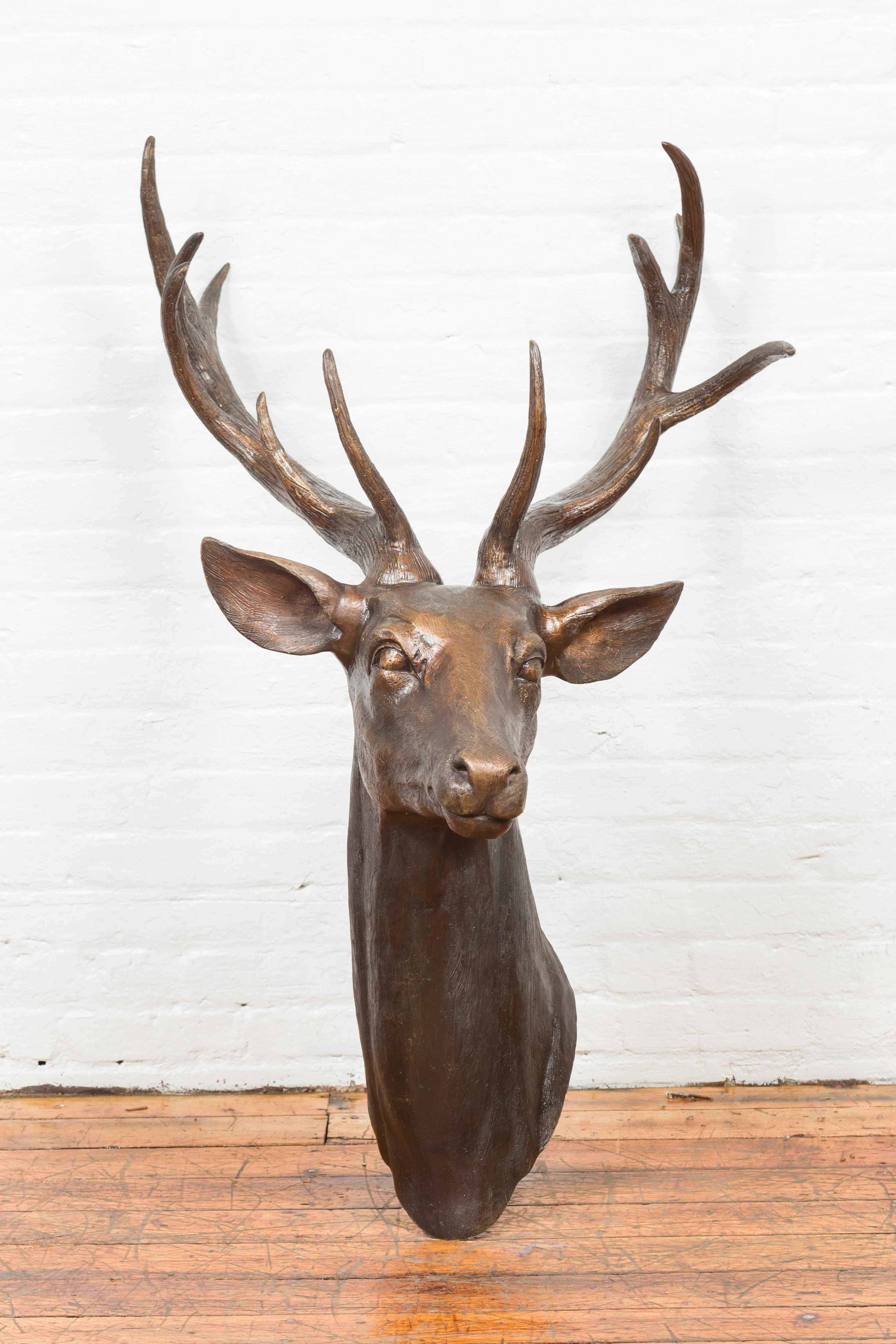 A contemporary bronze stag head sculpture with large antlers. Created with the traditional technique of the lost-wax (à la cire perdue) that allows a great precision and finesse in the details, this stag head attracts our attention with its great