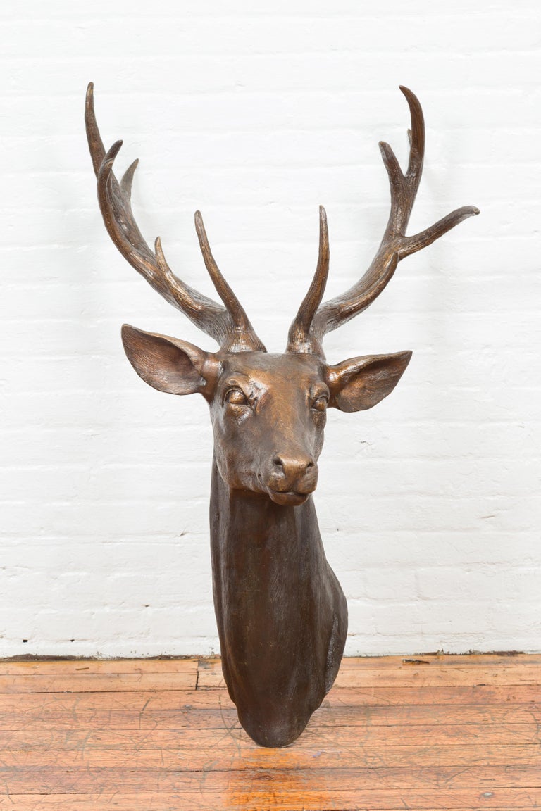 A contemporary bronze stag head sculpture with large antlers. Created with the traditional technique of the lost-wax (à la cire perdue) that allows a great precision and finesse in the details, this stag head attracts our attention with its great