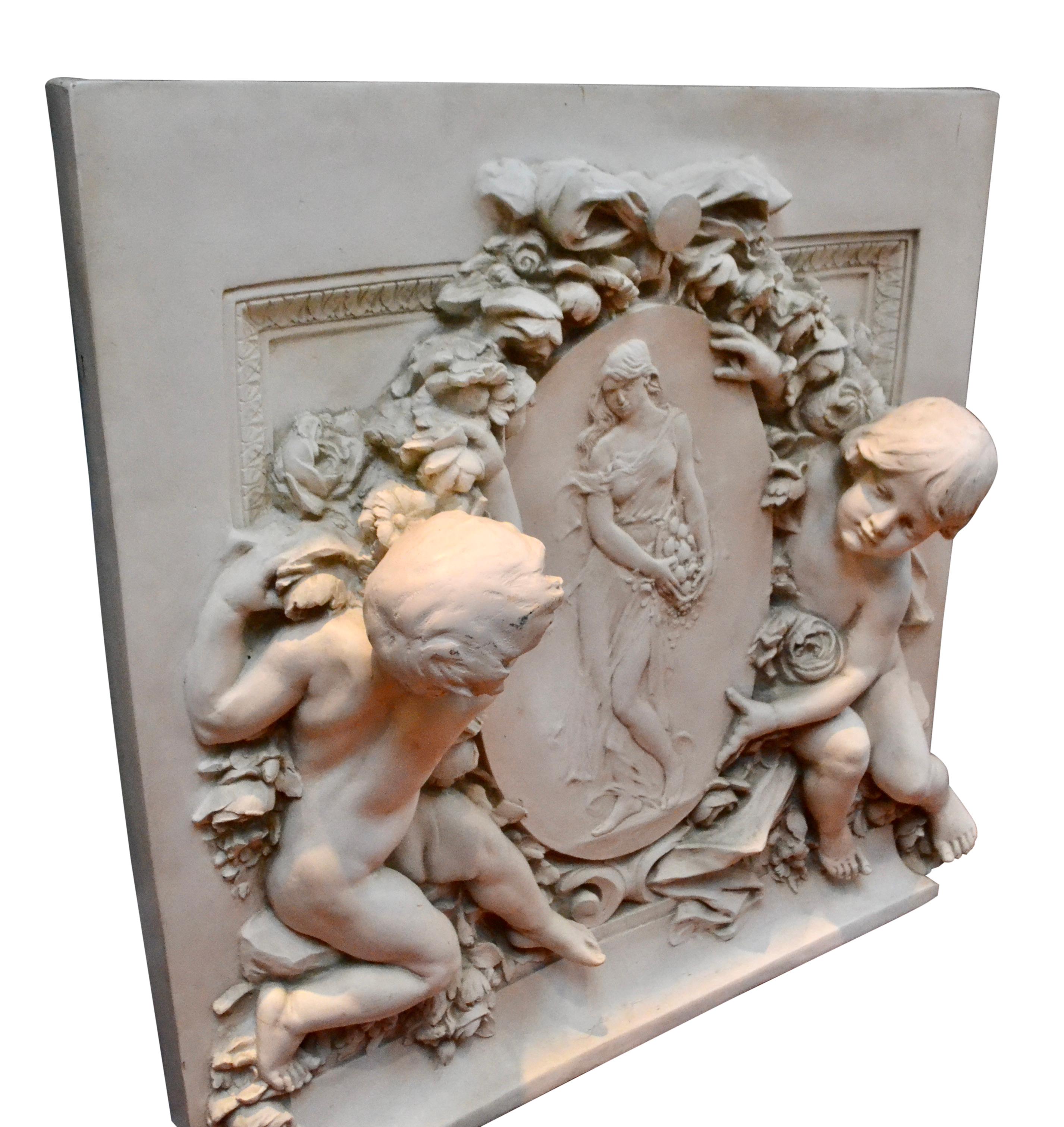 A large white rectangular contemporary resin wall plaque in high relief; showing two putti holding a cameo featuring a standing ‘art nouveau’ inspired maiden holding a basket of fruit. The cameo and putti backed with a ribbon and garlands of