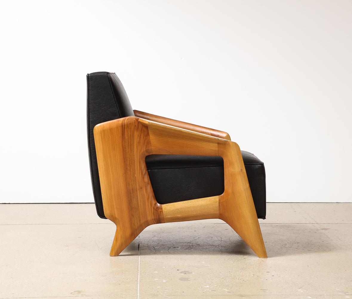 Low lounge chair made from Italian walnut. Sculpted sides and form. Frame is handmade in Italy.